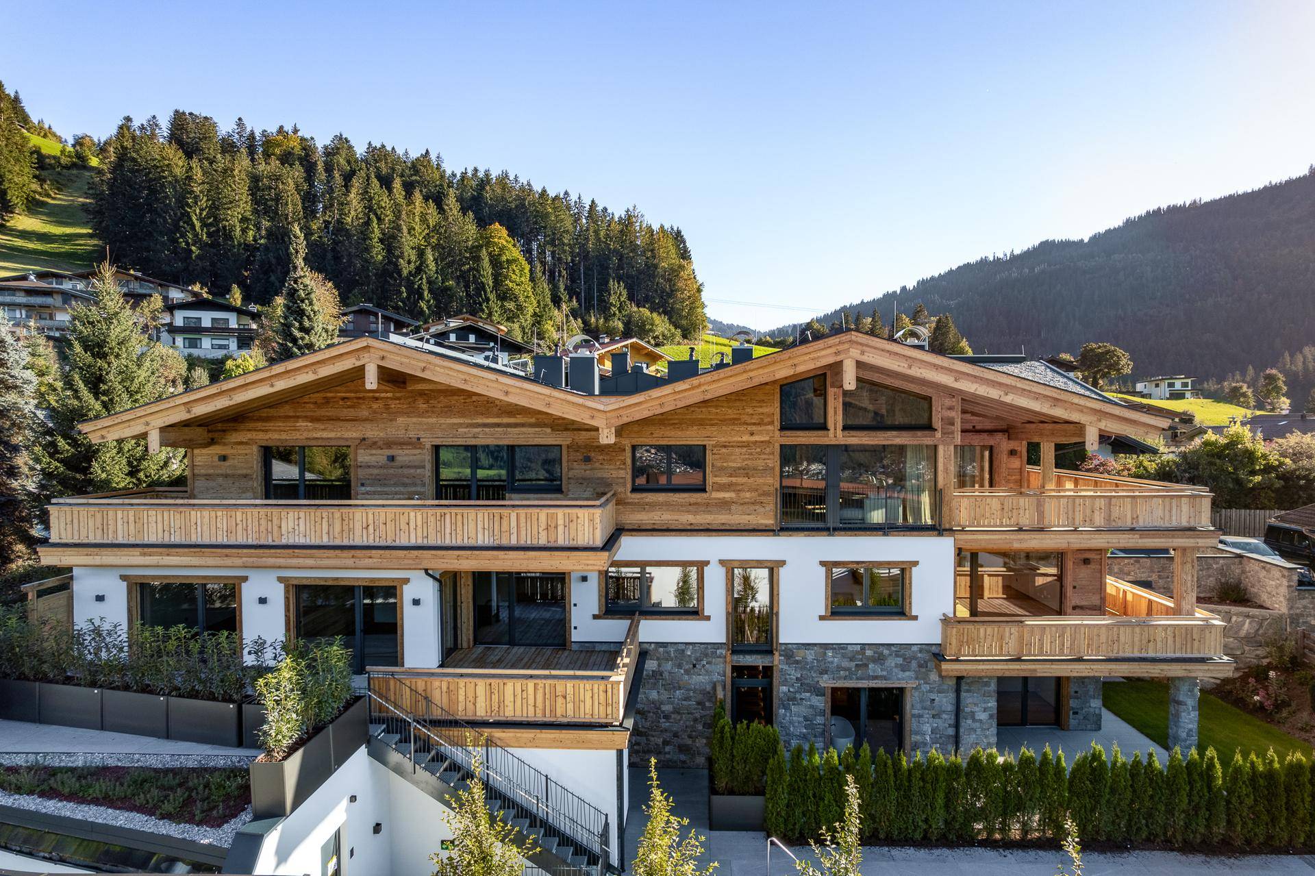 Beeindruckendes Holzchalet in alpiner Umgebung mit mehreren Balkonen und Terrassen.