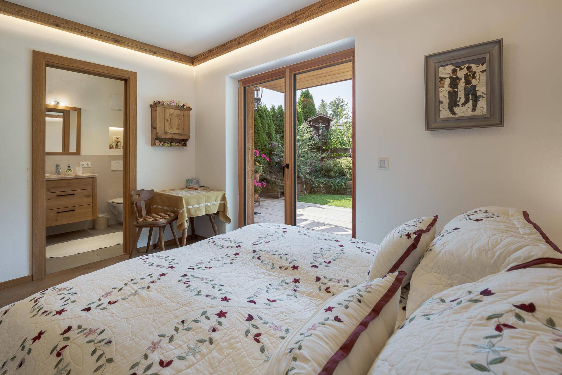Komfortables Schlafzimmer mit direktem Zugang zu einem modernen Badezimmer und Gartenblick.