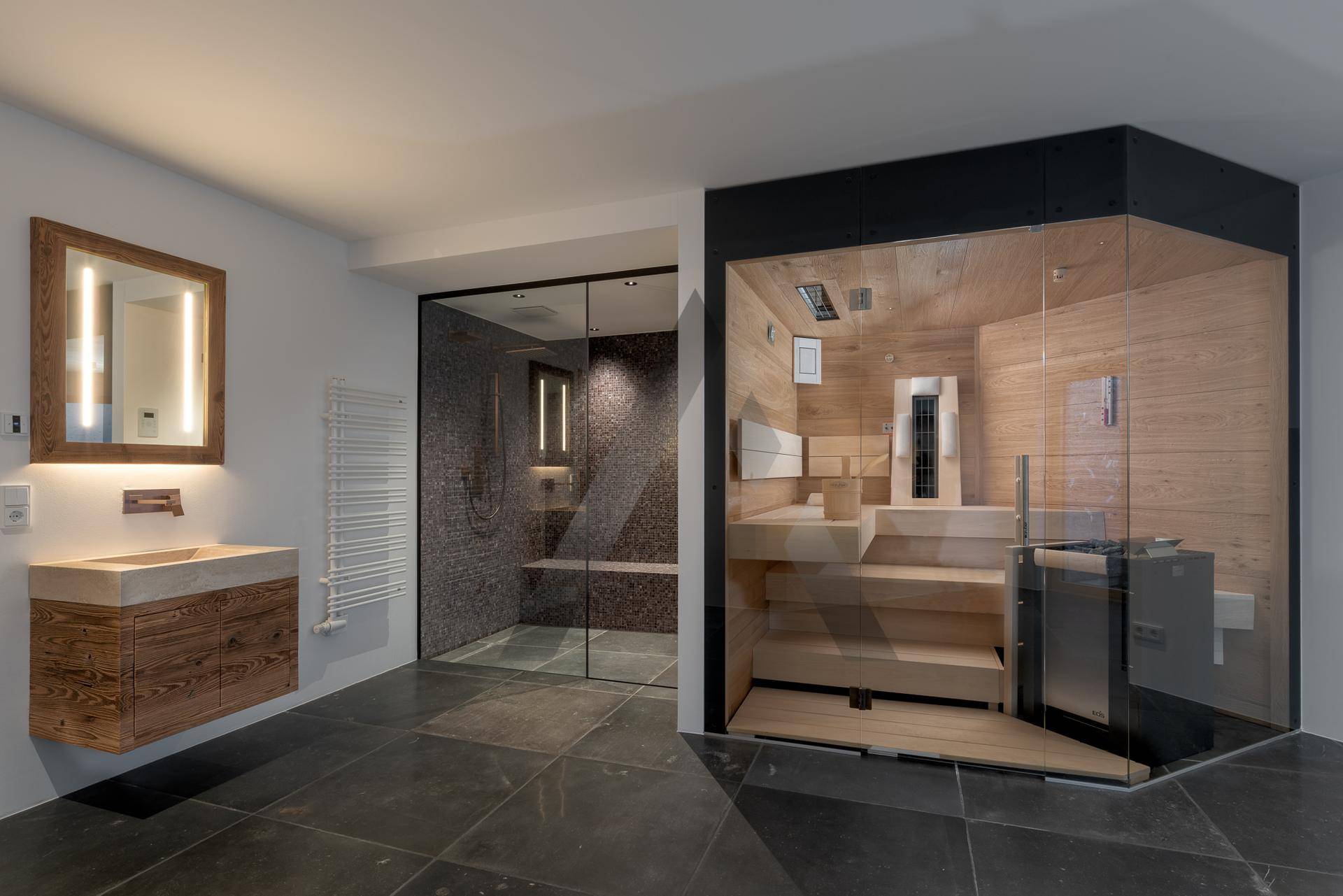 Exklusiver Wellnessbereich mit moderner Sauna, begehbarer Dusche und stilvollem Waschtisch.