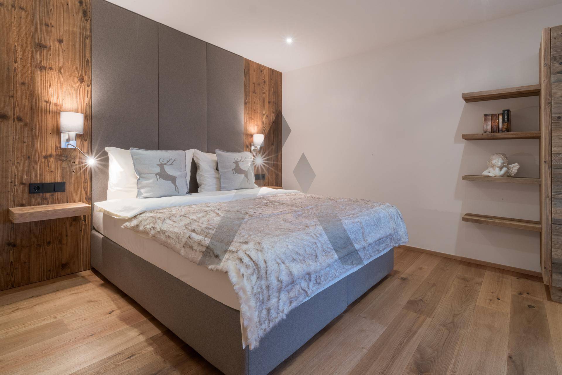 Gemütliches Schlafzimmer mit Holzwand, großem Bett und modernen Nachttischen.