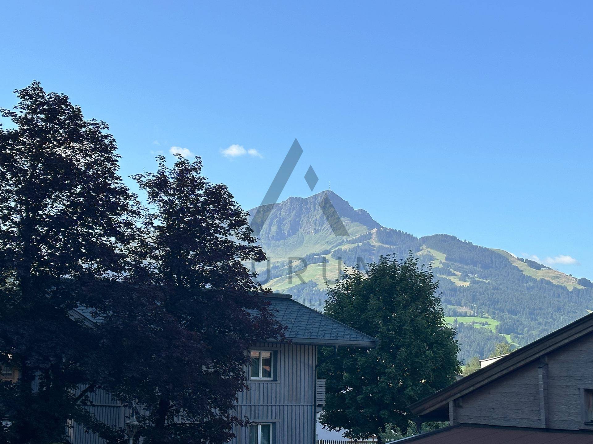 Panoramablick auf majestätische Berge über den Dächern der umliegenden Häuser.