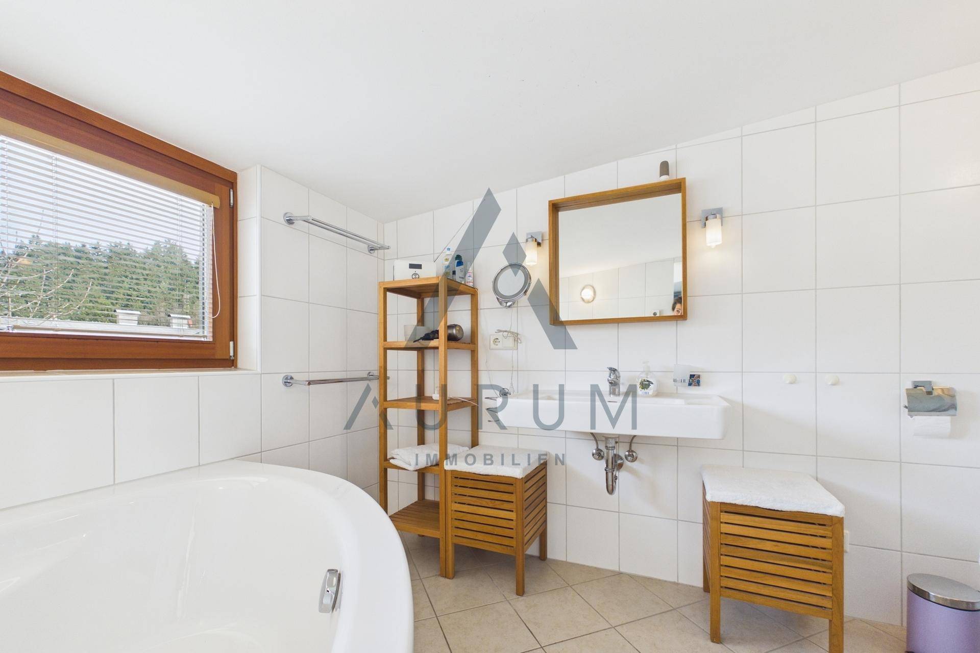 Helles Badezimmer mit Badewanne, Waschbecken und Fenster für natürliche Belüftung.