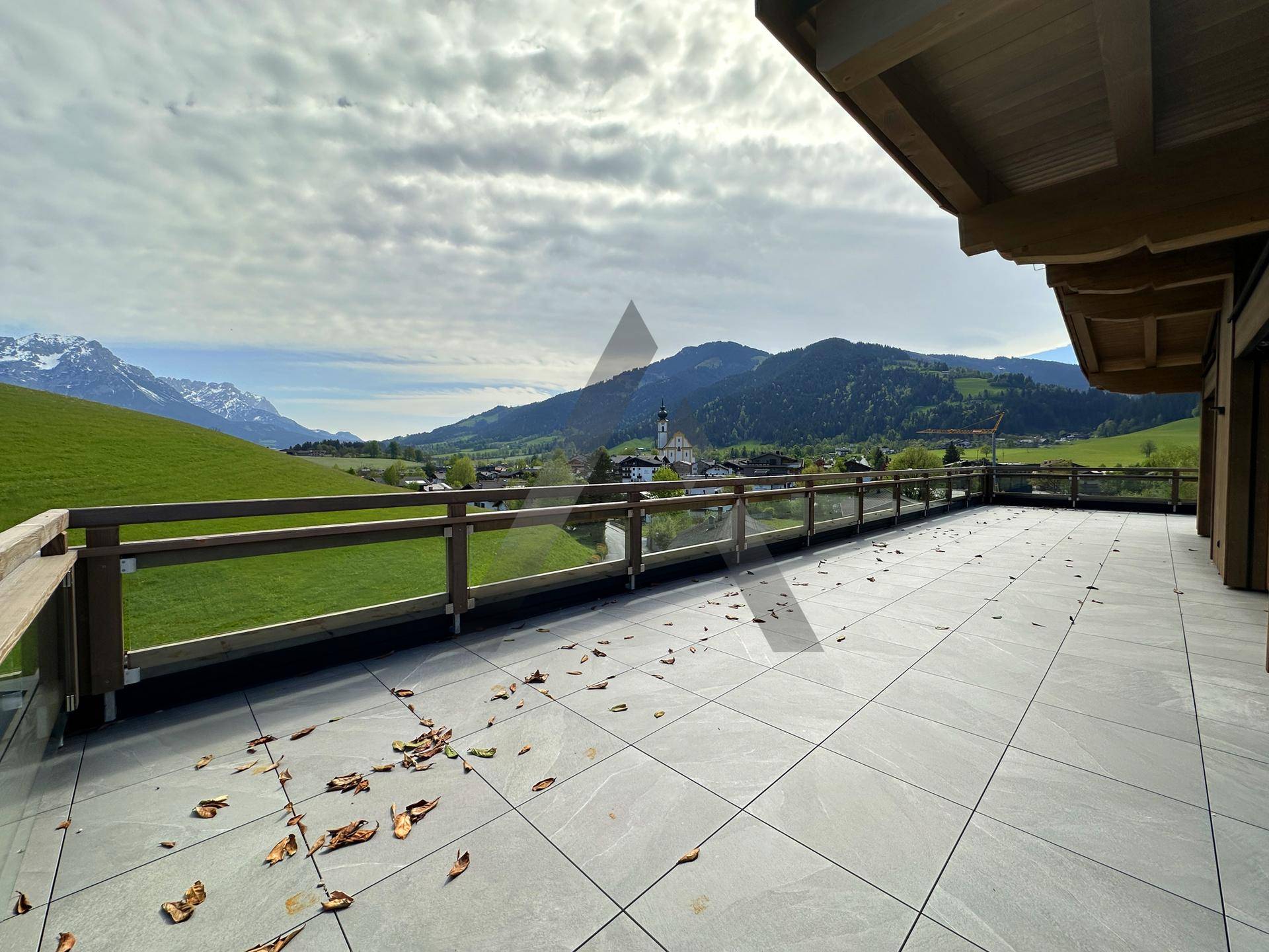 Großzügige Terrasse mit Panoramablick auf das Dorf und die umliegende Bergwelt.