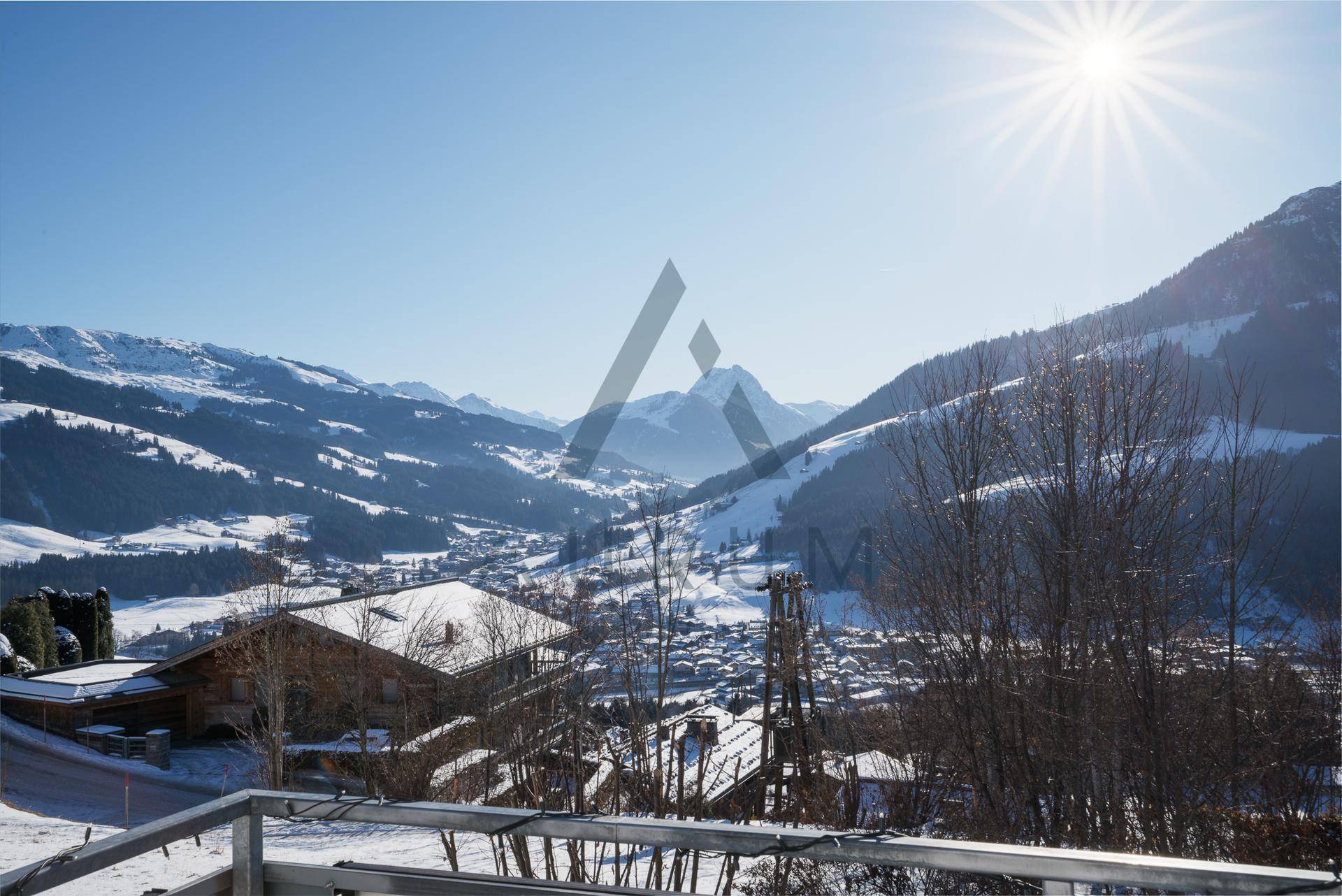 Atemberaubender Panoramablick von einem Balkon auf die verschneite Berglandschaft und das Tal.