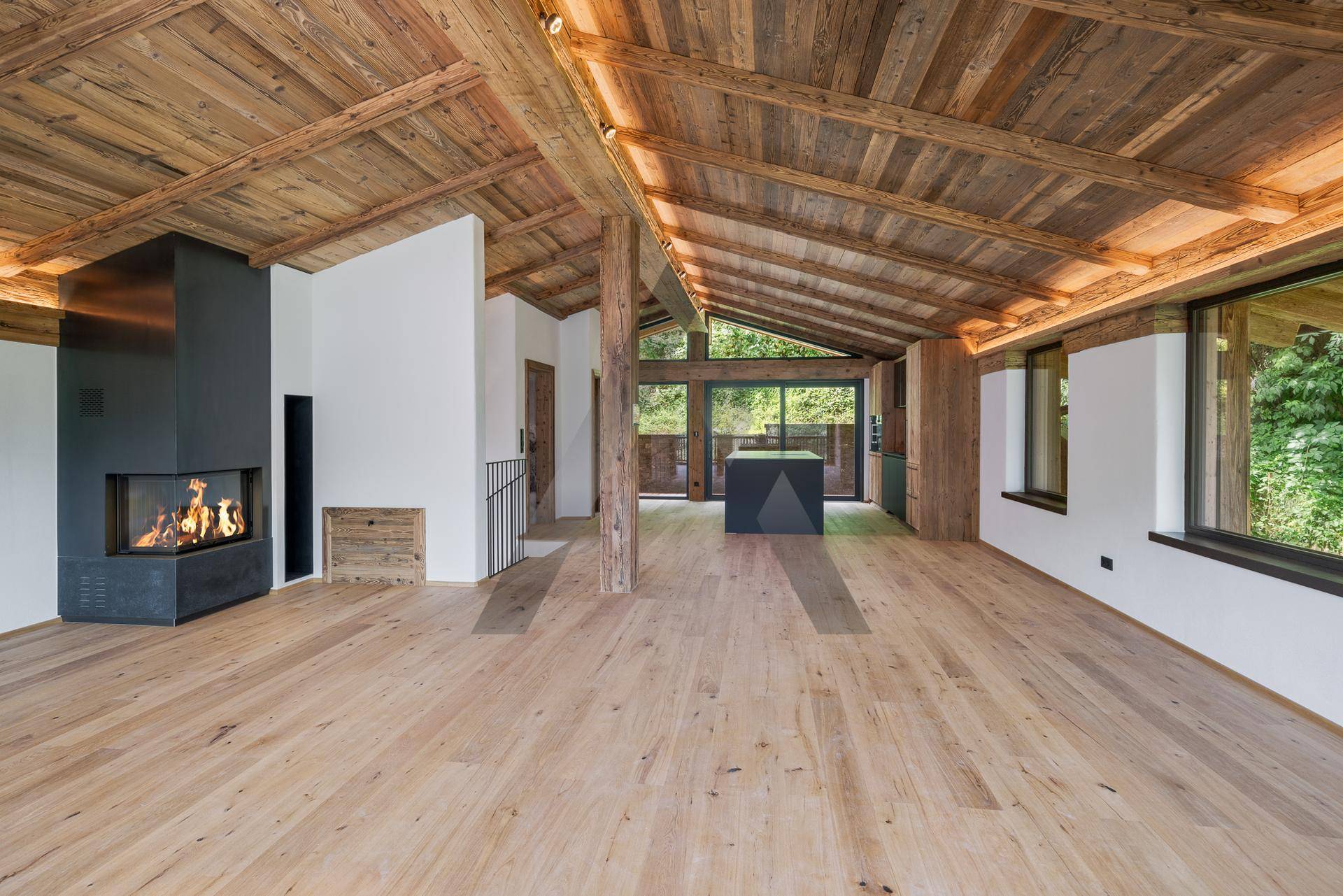 Geräumiger Wohnbereich mit modernem Kamin, Holzbalkendecke und Eichenparkett, lichtdurchflutet.