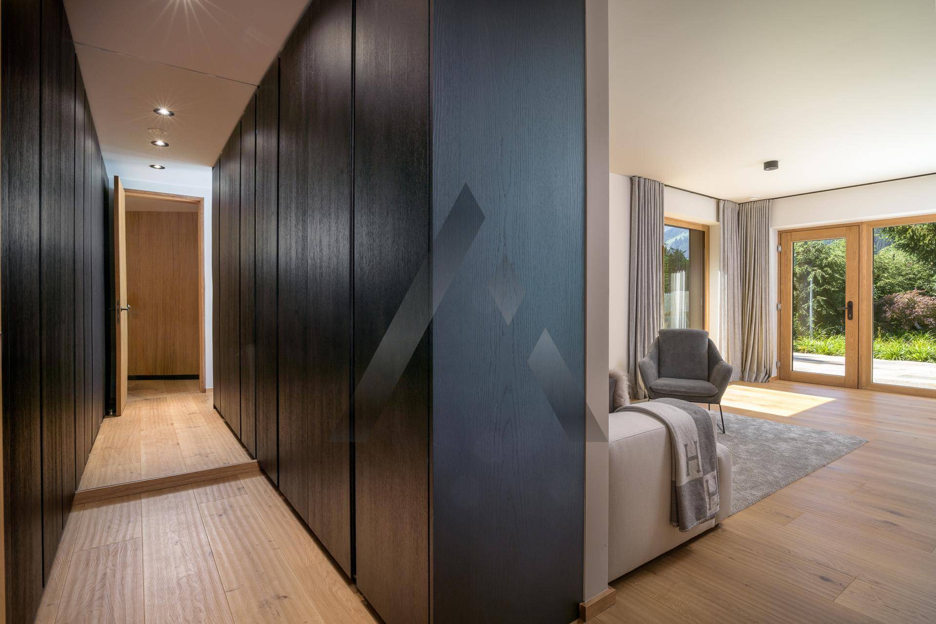 Flur mit eleganten Einbauschränken und Blick in ein helles Schlafzimmer.