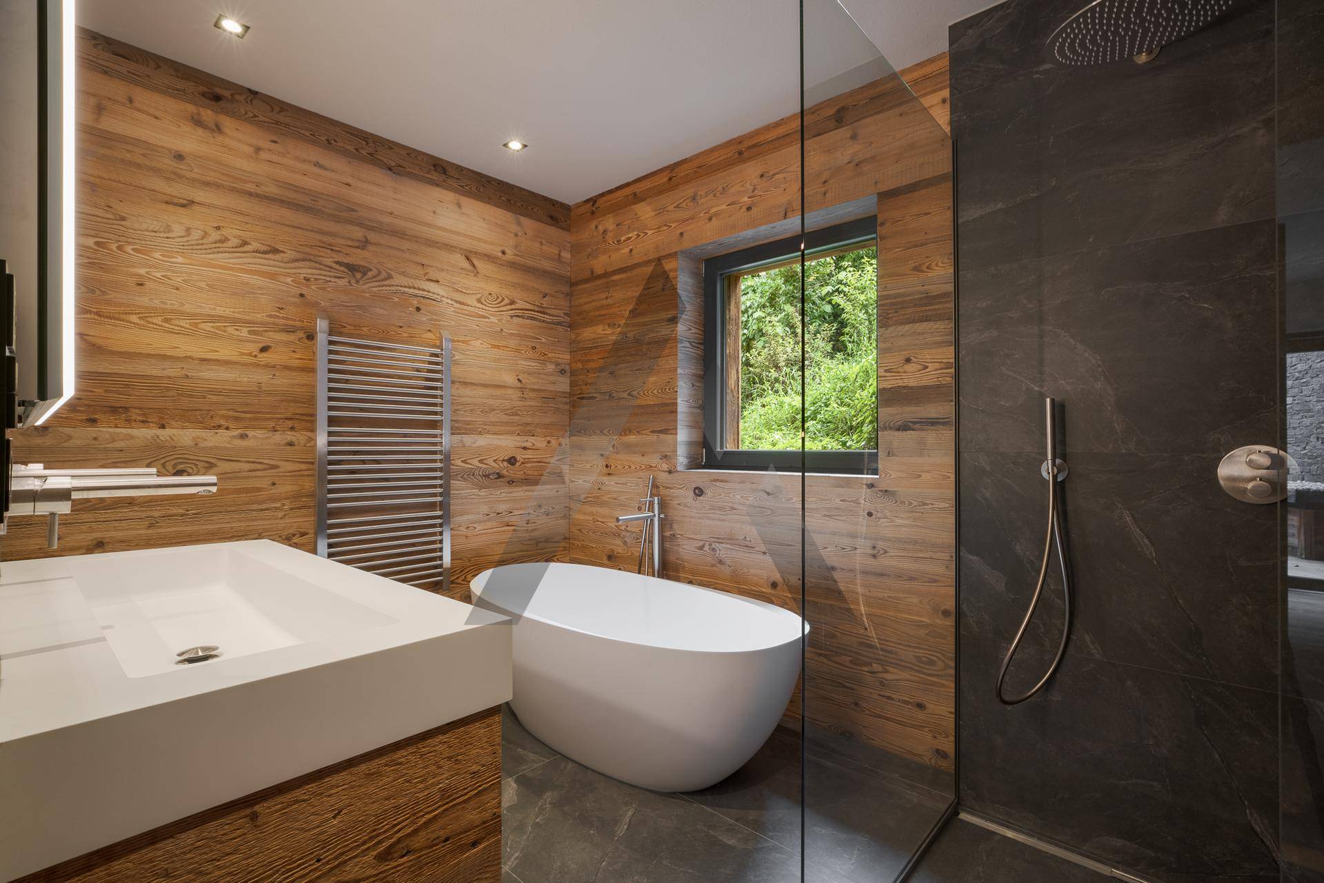 Elegantes Badezimmer mit freistehender Badewanne, Dusche und Holzwänden, hell und modern.