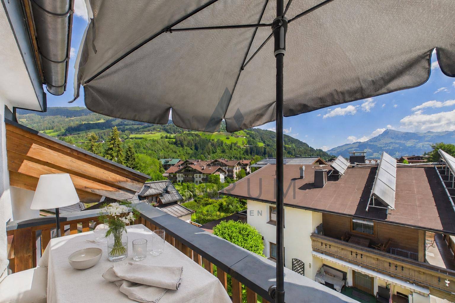 Gemütlicher Balkon mit Tisch und Stühlen, ideal für Mahlzeiten im Freien mit Bergblick.