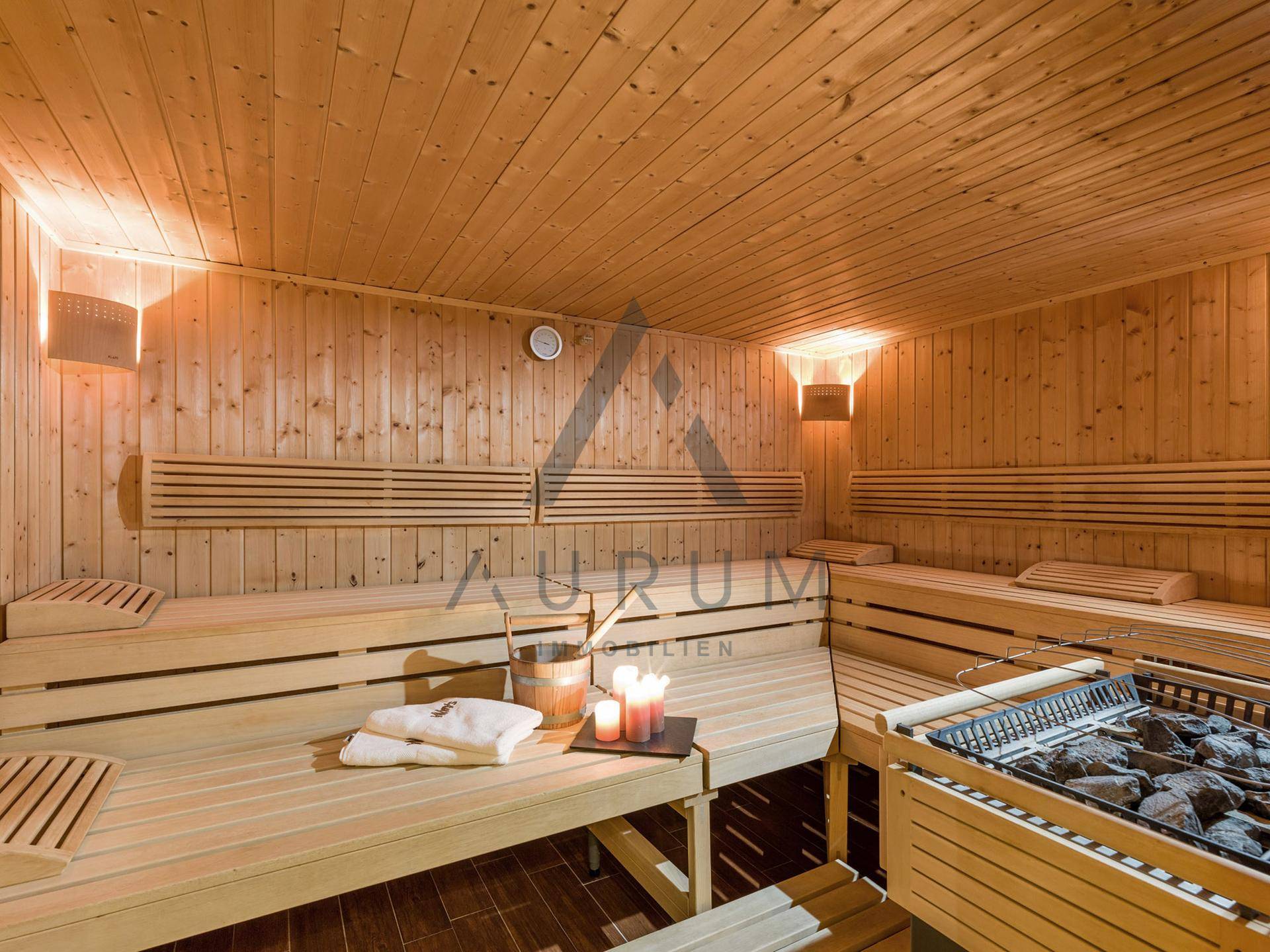 Traditionelle Holzsauna mit mehreren Bänken und einem Saunaofen, bereit zur Nutzung.