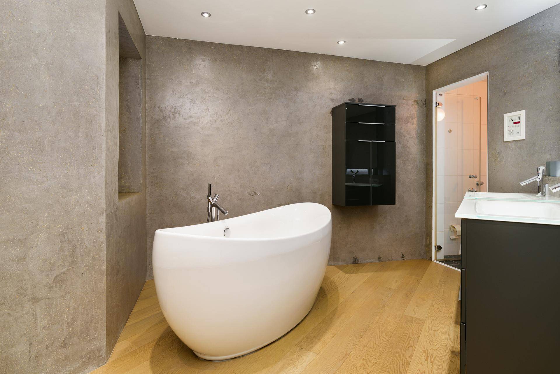 Elegantes Badezimmer mit freistehender Badewanne und modernen Armaturen.