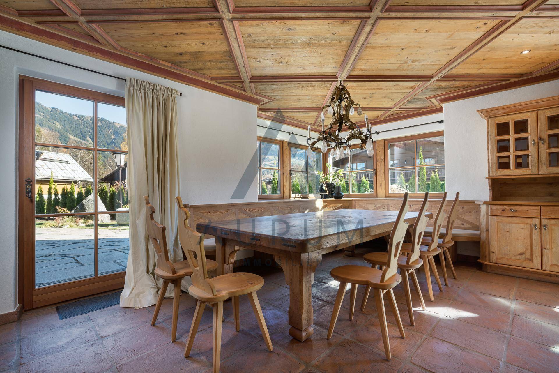 Traditioneller Essbereich mit Holztisch, Eckbank und Blick auf die umliegende Natur.