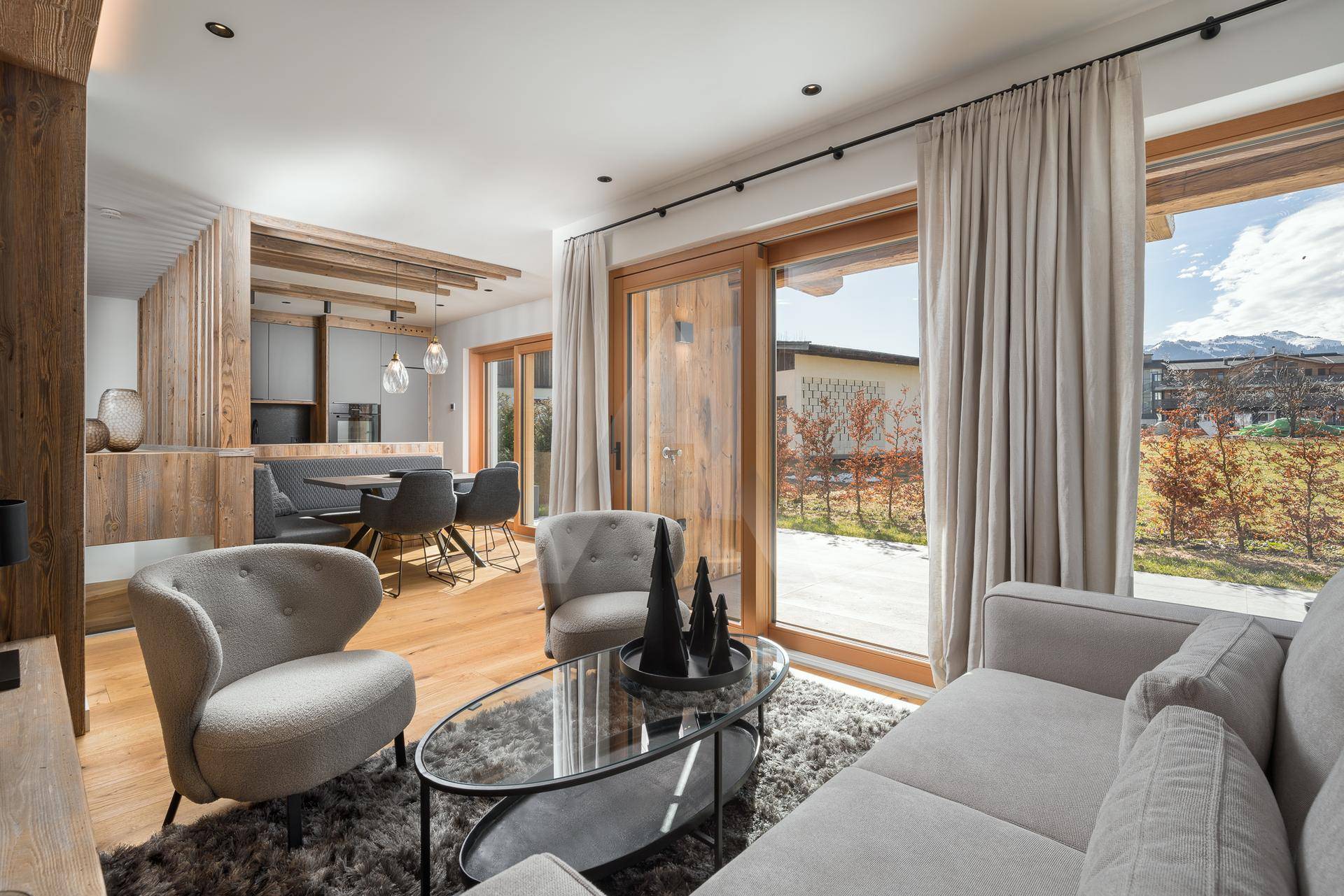 Heller Wohn- und Essbereich mit Holzboden, modernen Möbeln und Zugang zur Terrasse.