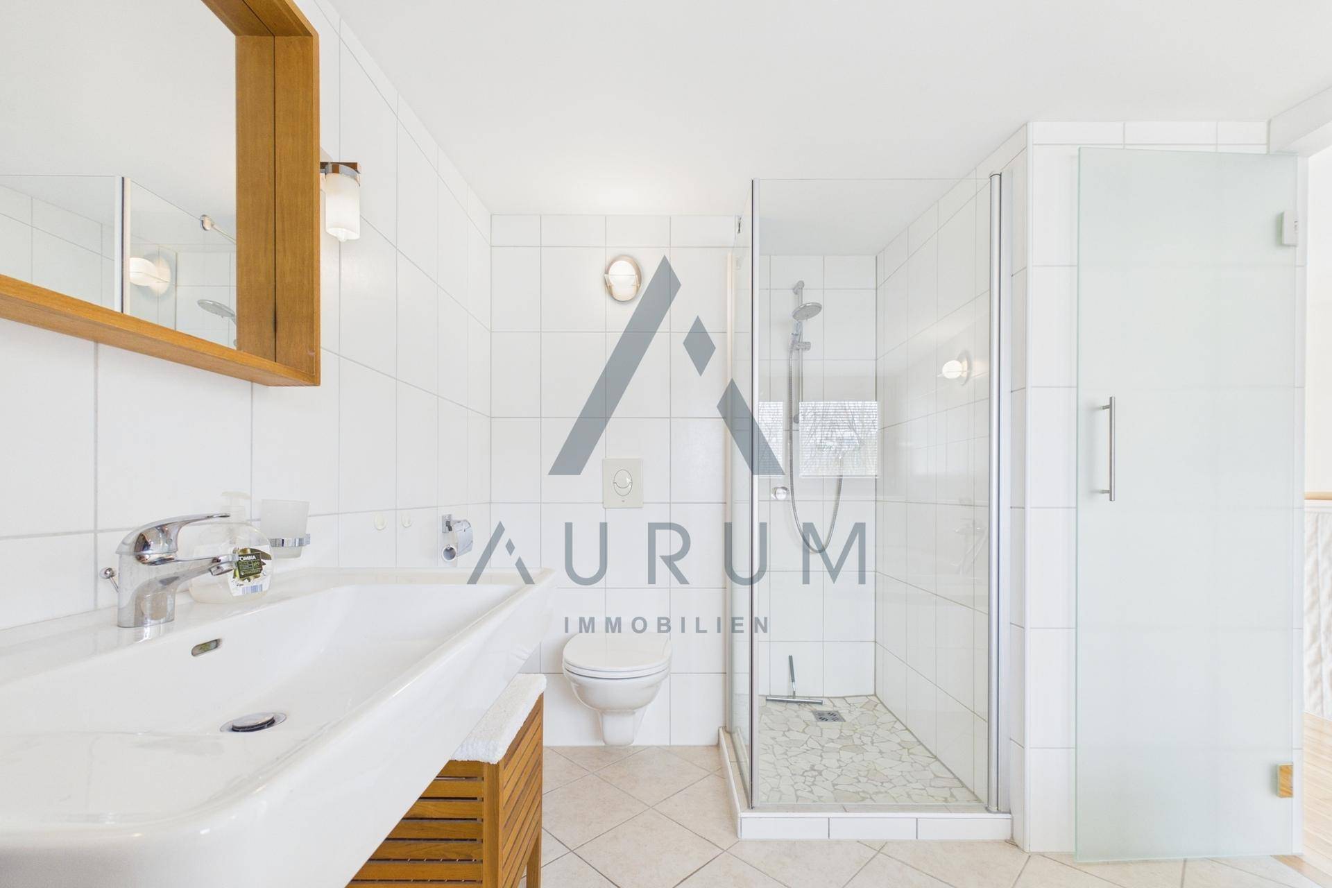 Modernes Badezimmer mit ebenerdiger Dusche, Waschbecken und weißen Fliesen.