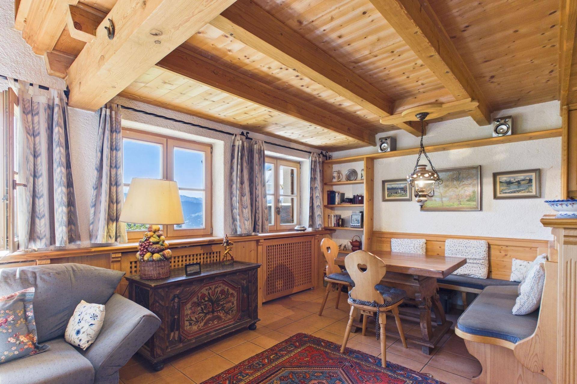Gemütlicher Essbereich mit Holzbänken und Blick auf die umliegende Berglandschaft.