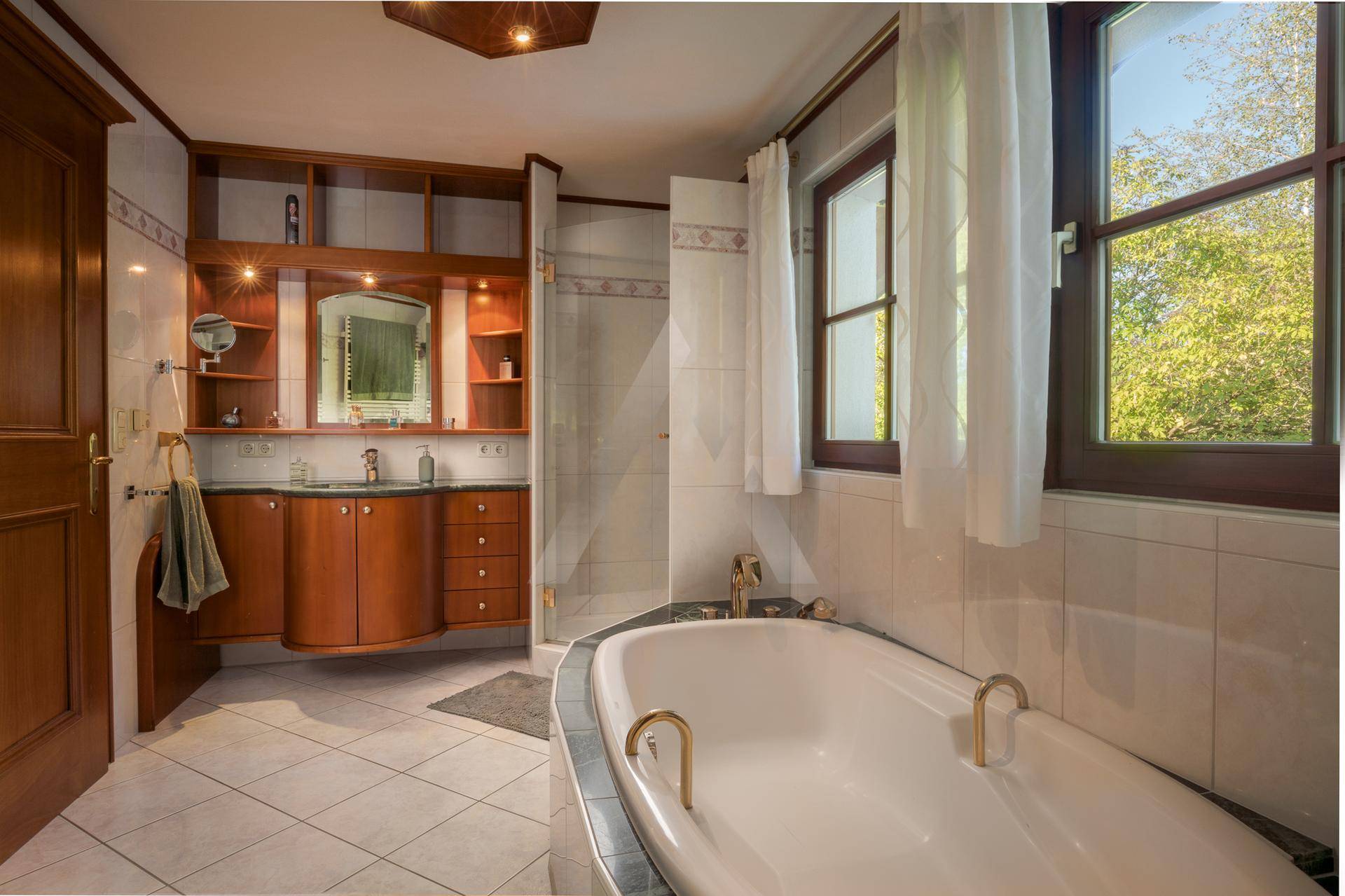 Geräumiges Badezimmer mit Badewanne, Dusche, Doppelwaschbecken und Fenster.