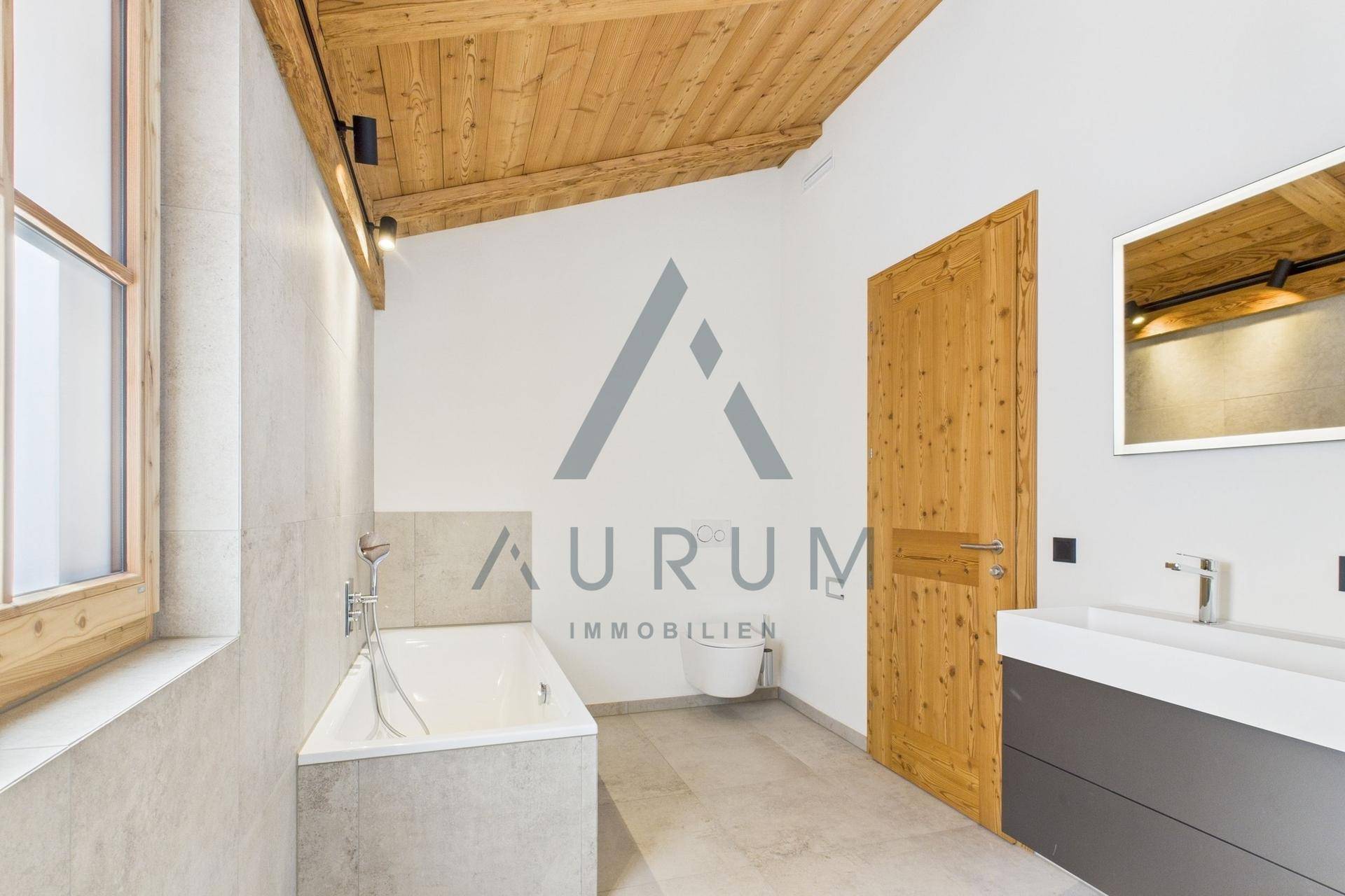 Helles Badezimmer mit Badewanne, modernem Waschtisch und Holztür.