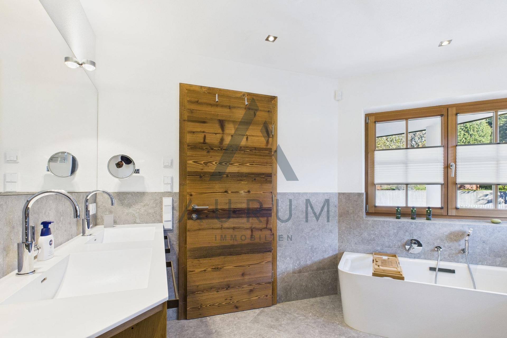 Modernes Badezimmer mit Doppelwaschbecken, Badewanne und Fenster.