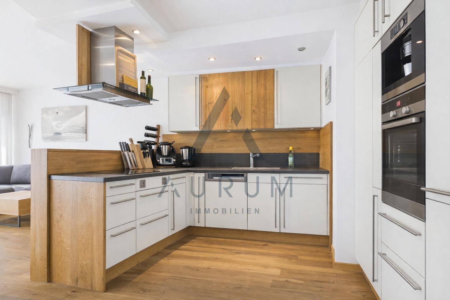 Moderne Einbauküche mit Holz- und weißen Fronten, Kochinsel und hochwertigen Geräten.