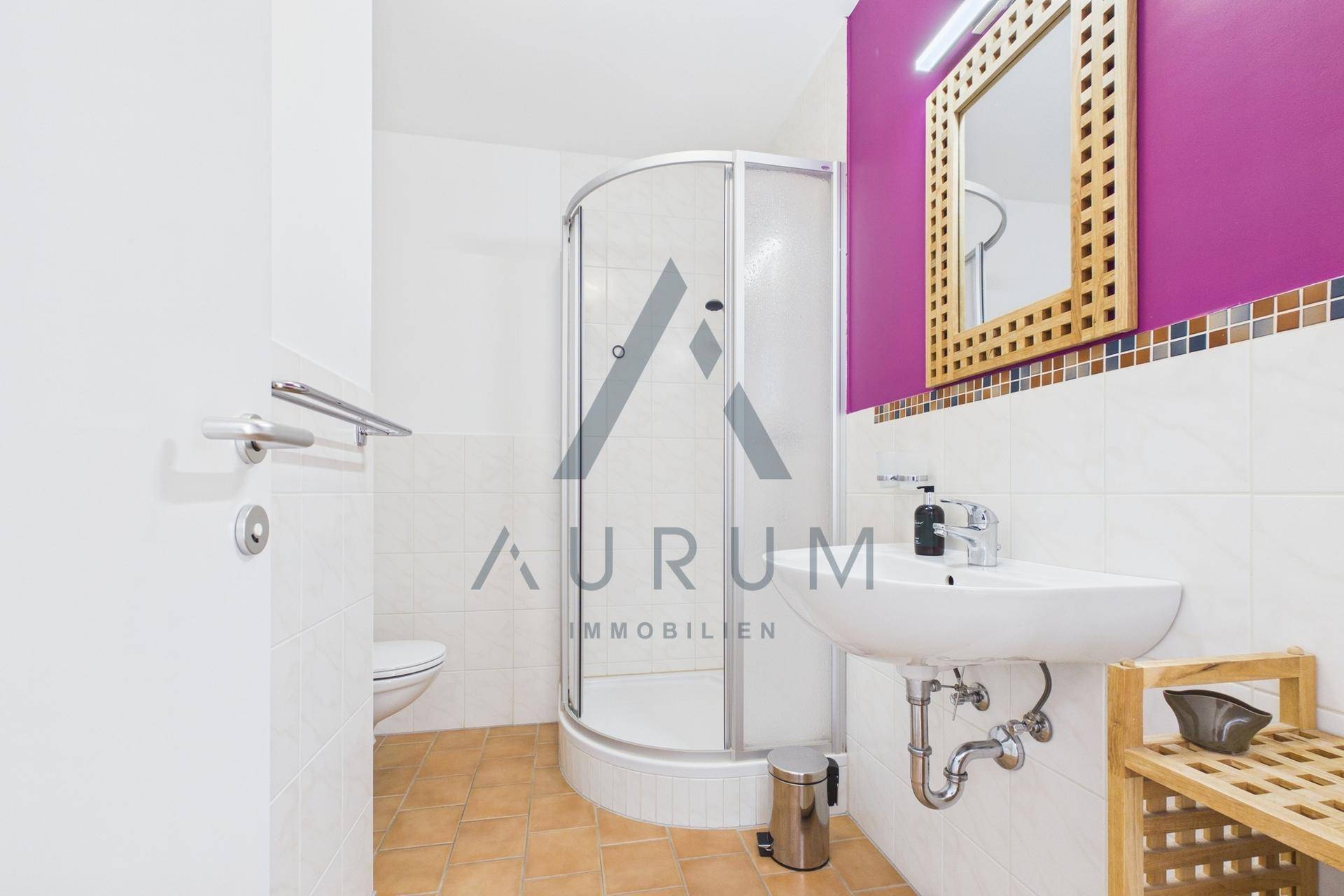 Modernes Badezimmer mit Duschkabine, Waschbecken und farbiger Akzentwand.