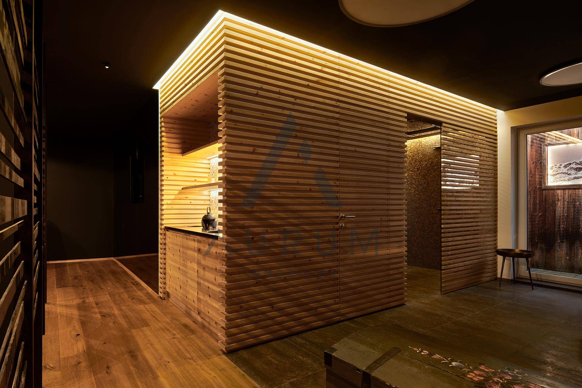 Moderner Wellnessbereich mit Holzverkleidung, integrierter Bar und Zugang zur Sauna.