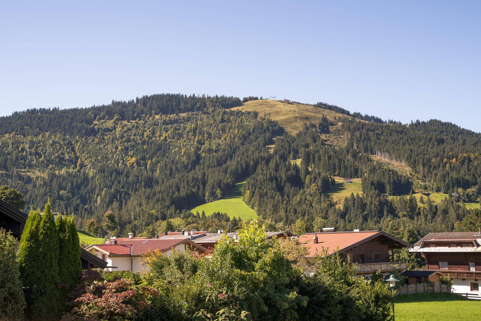 Weitläufiger Blick auf die bewaldeten Hügel und die alpine Landschaft.