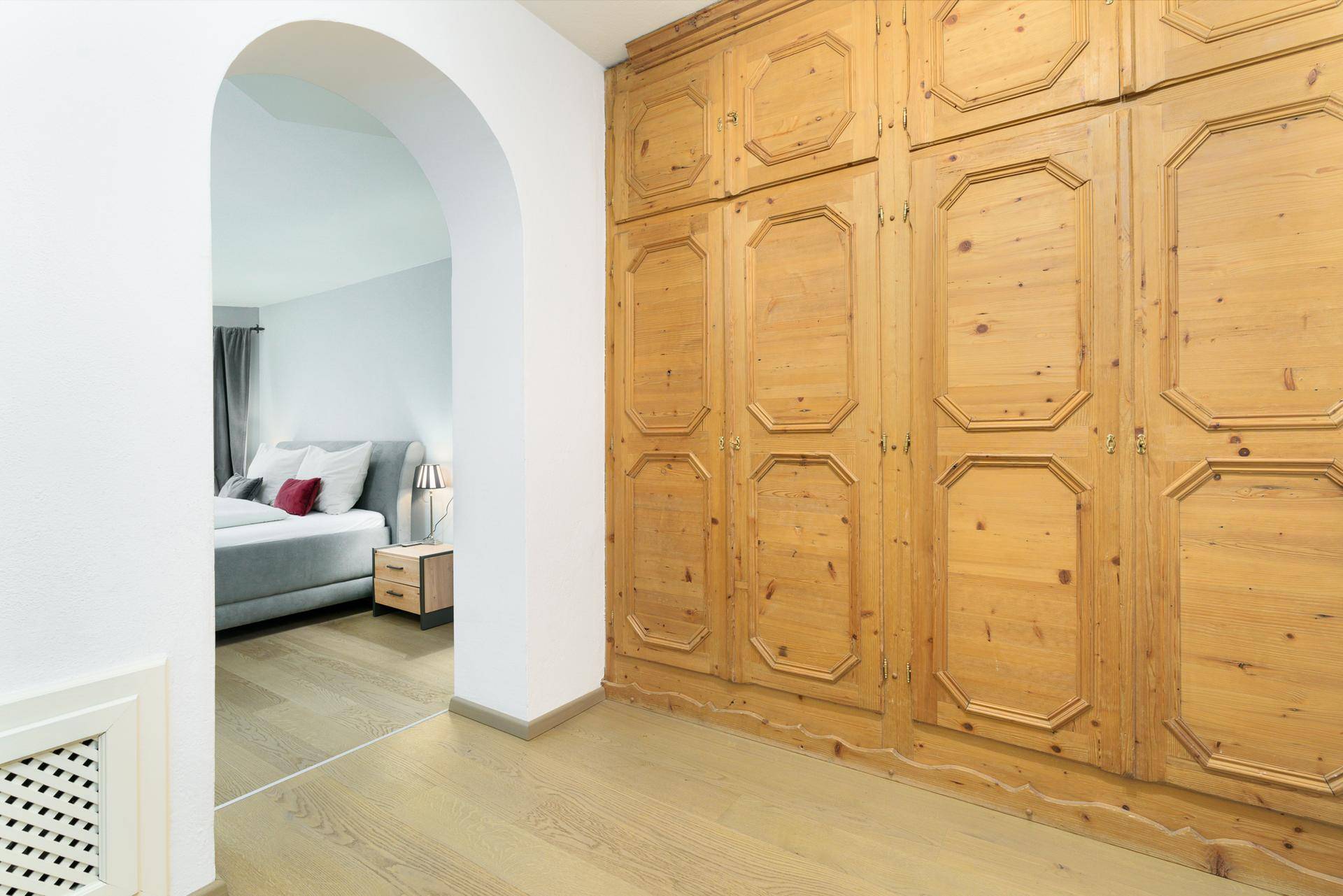 Flur mit großem Einbauschrank aus Holz und Zugang zu einem Schlafzimmer.