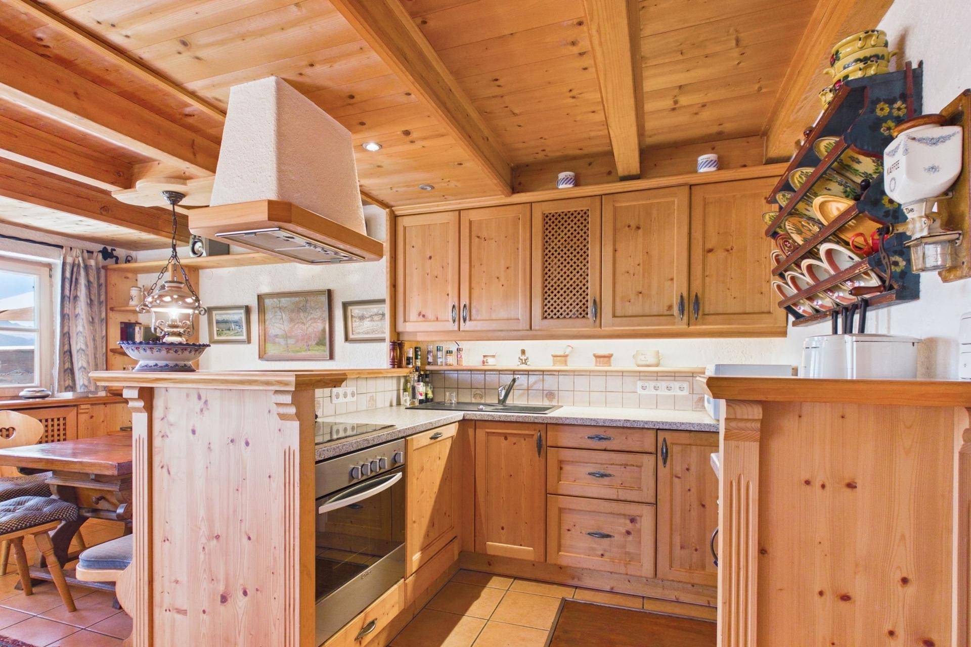 Traditionelle Holzküche im Landhausstil mit integrierten Geräten und Essbereich.