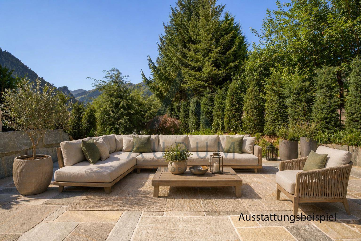 Großzügige möblierte Terrasse mit Lounge-Sofa, umgeben von viel Grün und Bergblick.