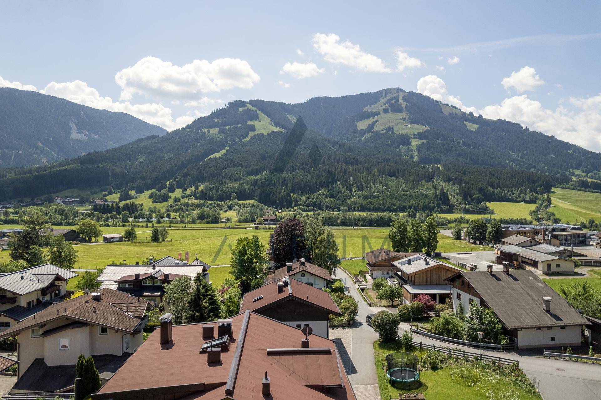 Malerischer Ausblick auf eine Berglandschaft mit grünen Wiesen und einem Dorf im Tal.
