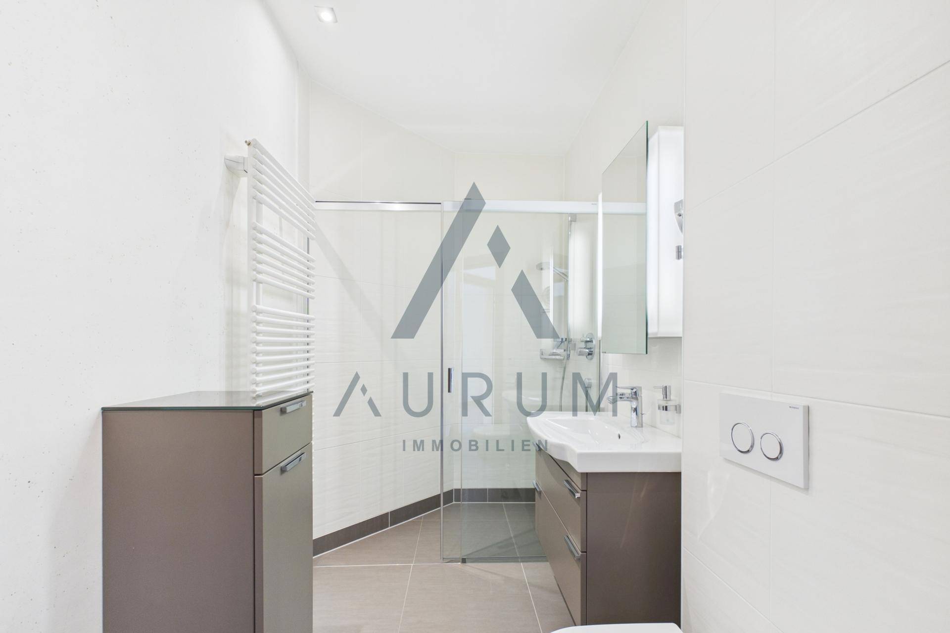 Modernes Badezimmer mit Dusche, Waschtisch und beheiztem Handtuchhalter in hellem Design.