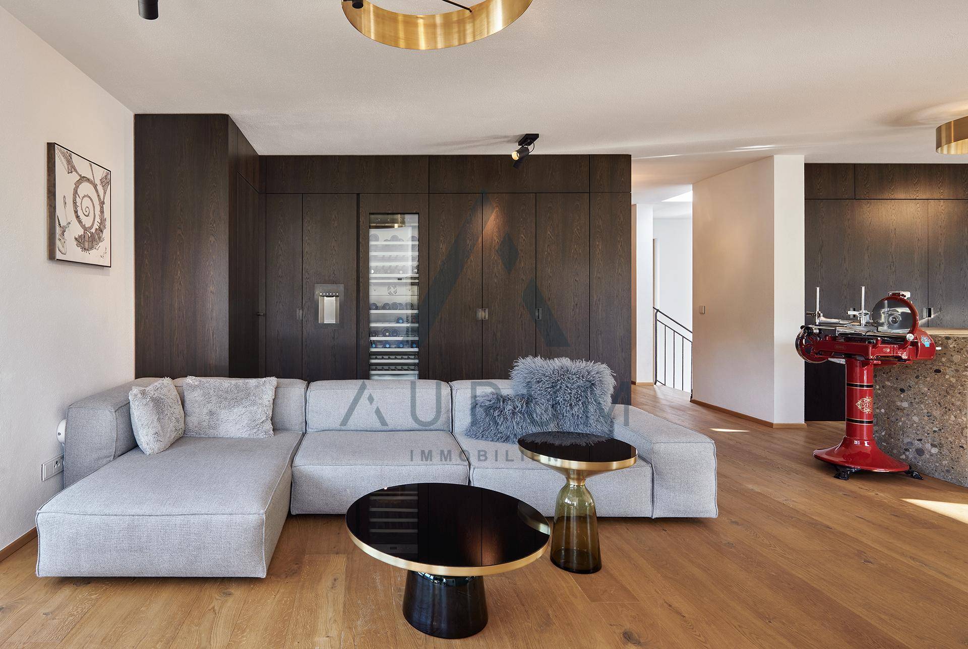 Gemütlicher Wohnbereich mit großem Sofa, Holzboden und integriertem Weinkühlschrank.
