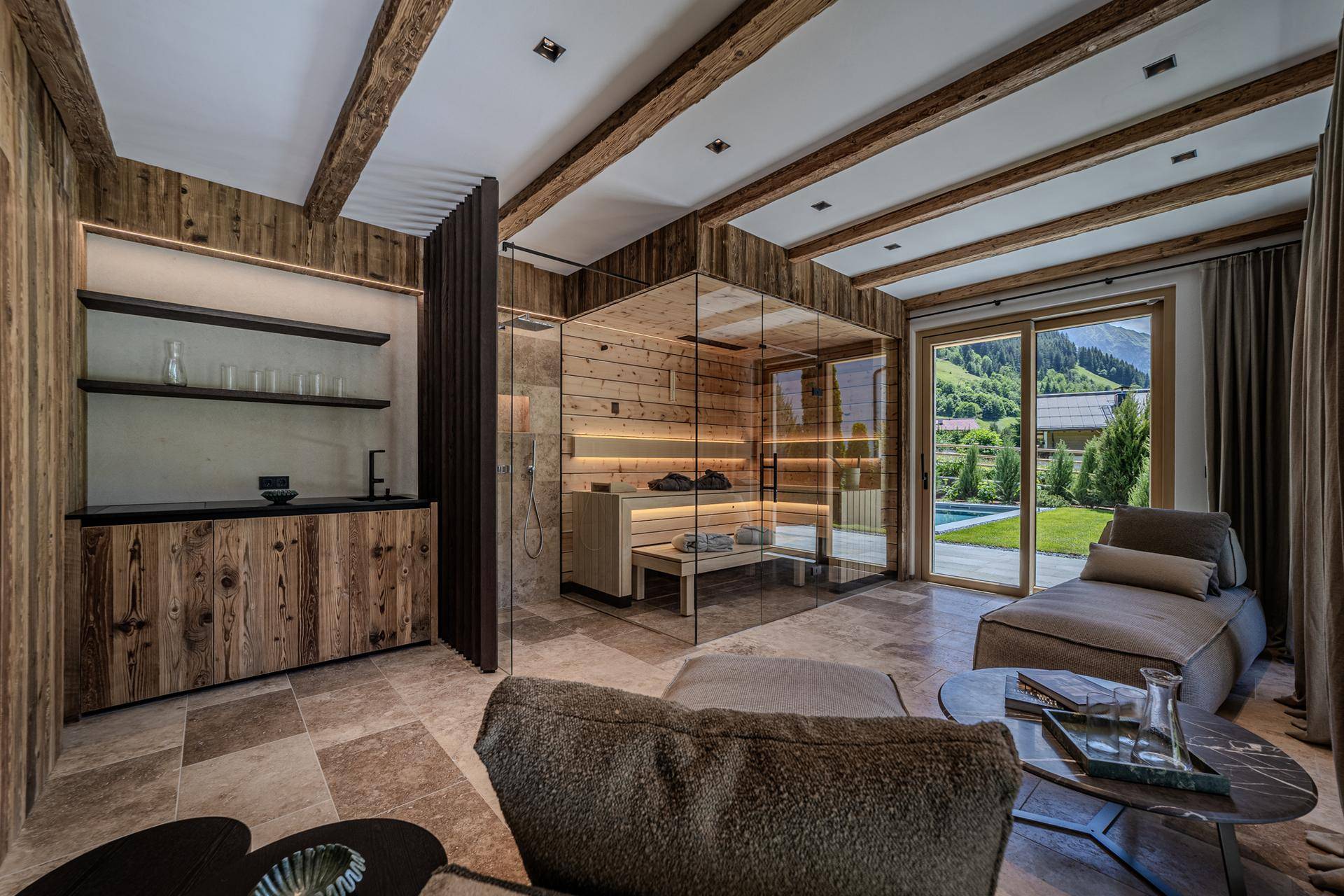 Exklusiver Wellnessbereich mit Sauna, Dusche und Entspannungsliege mit Blick ins Grüne.