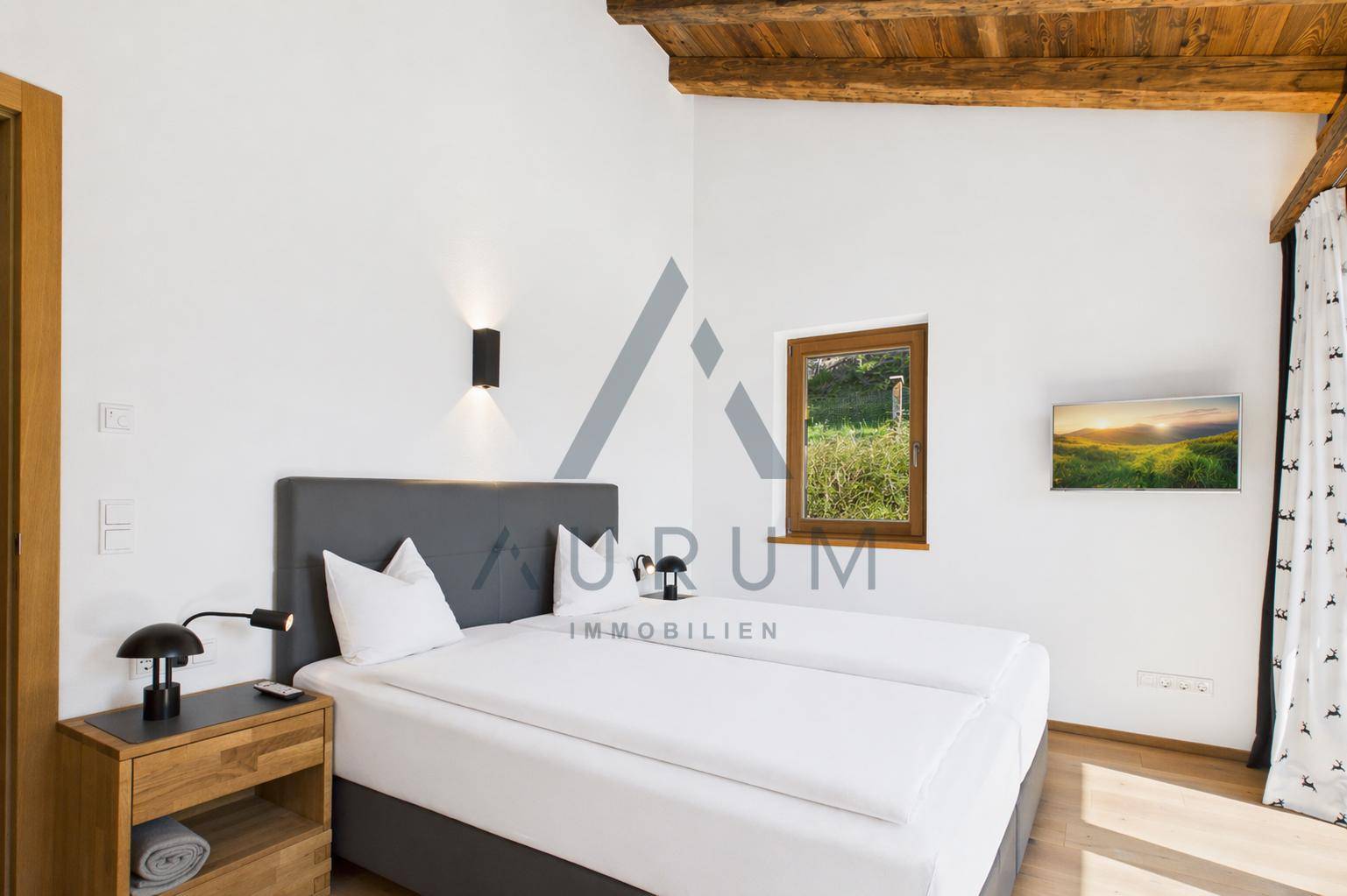 Gemütliches Schlafzimmer mit Doppelbett, Holzelementen und kleinem Fenster.