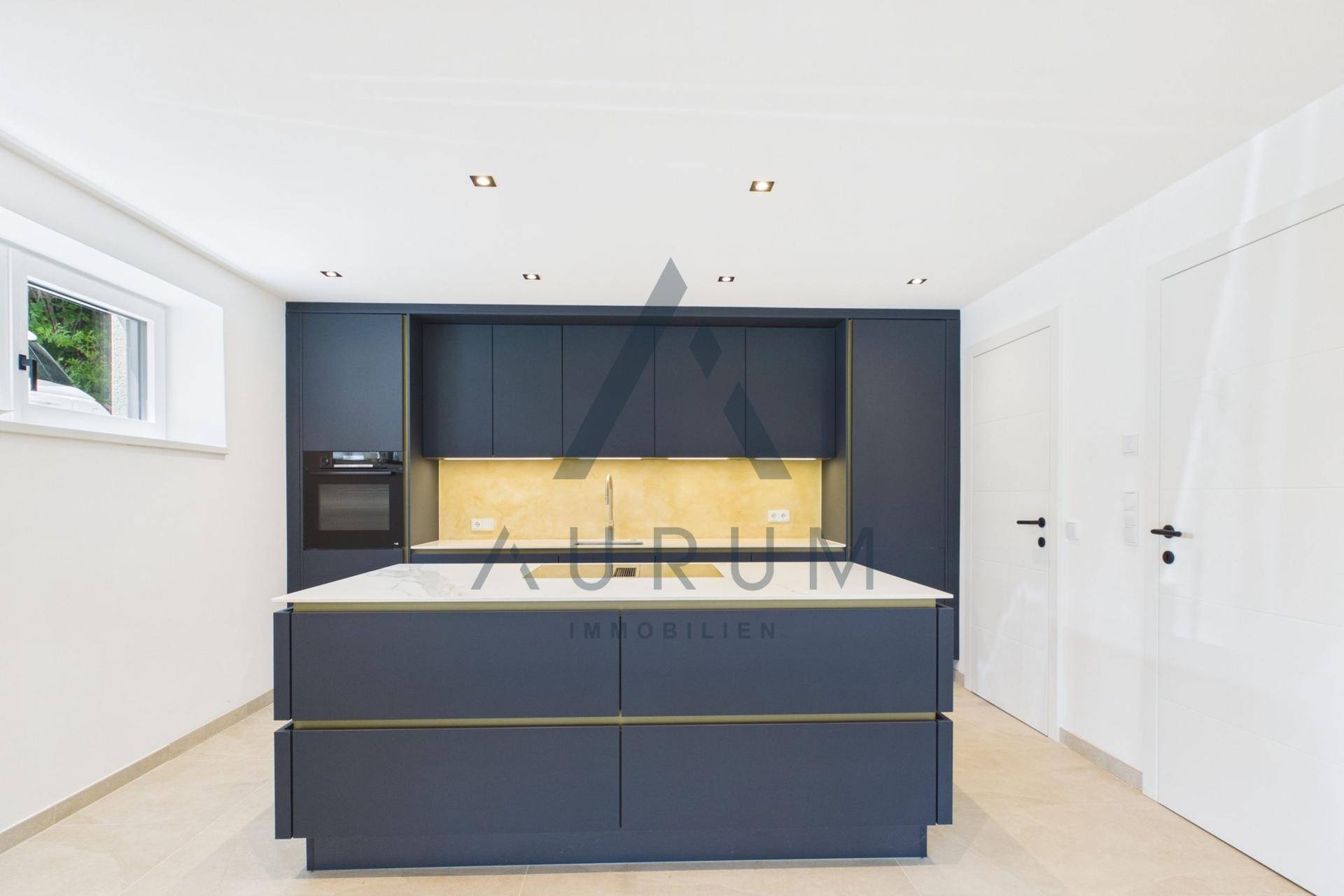 Moderne Einbauküche in Dunkelblau mit Kücheninsel und integrierten Geräten.