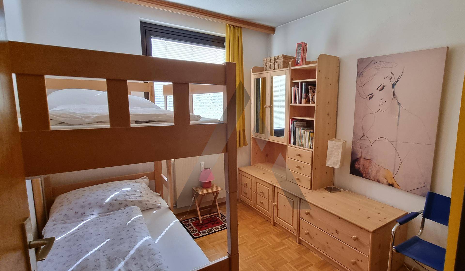 Schlafzimmer mit Etagenbett, Holzmöbeln und Parkettboden, ideal für Kinder oder Gäste