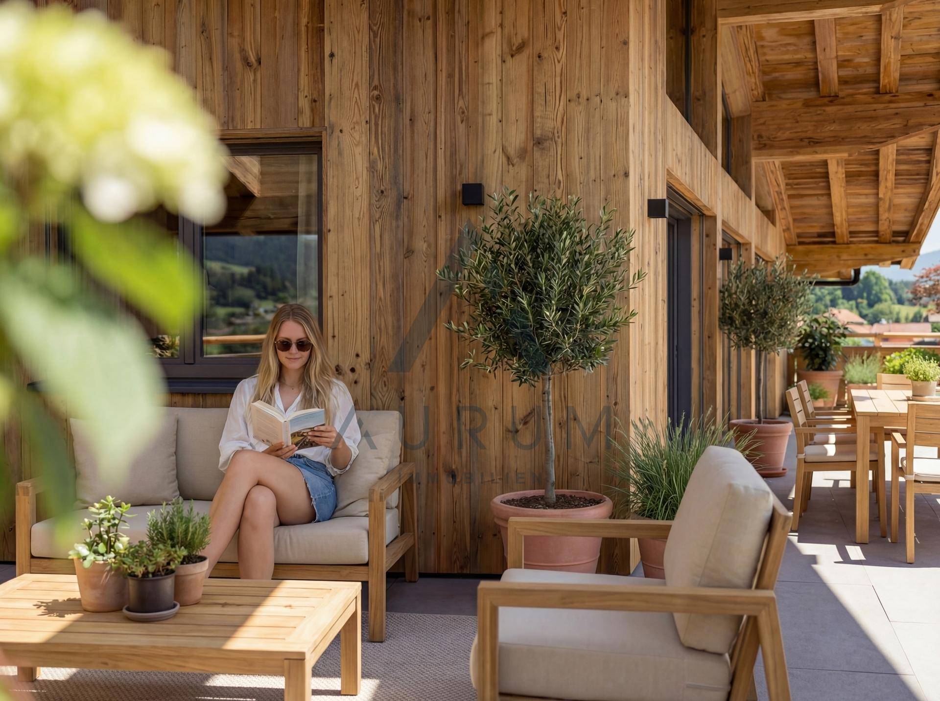 Gemütlicher Lounge-Bereich auf der Dachterrasse mit Holzwänden und Topfpflanzen.