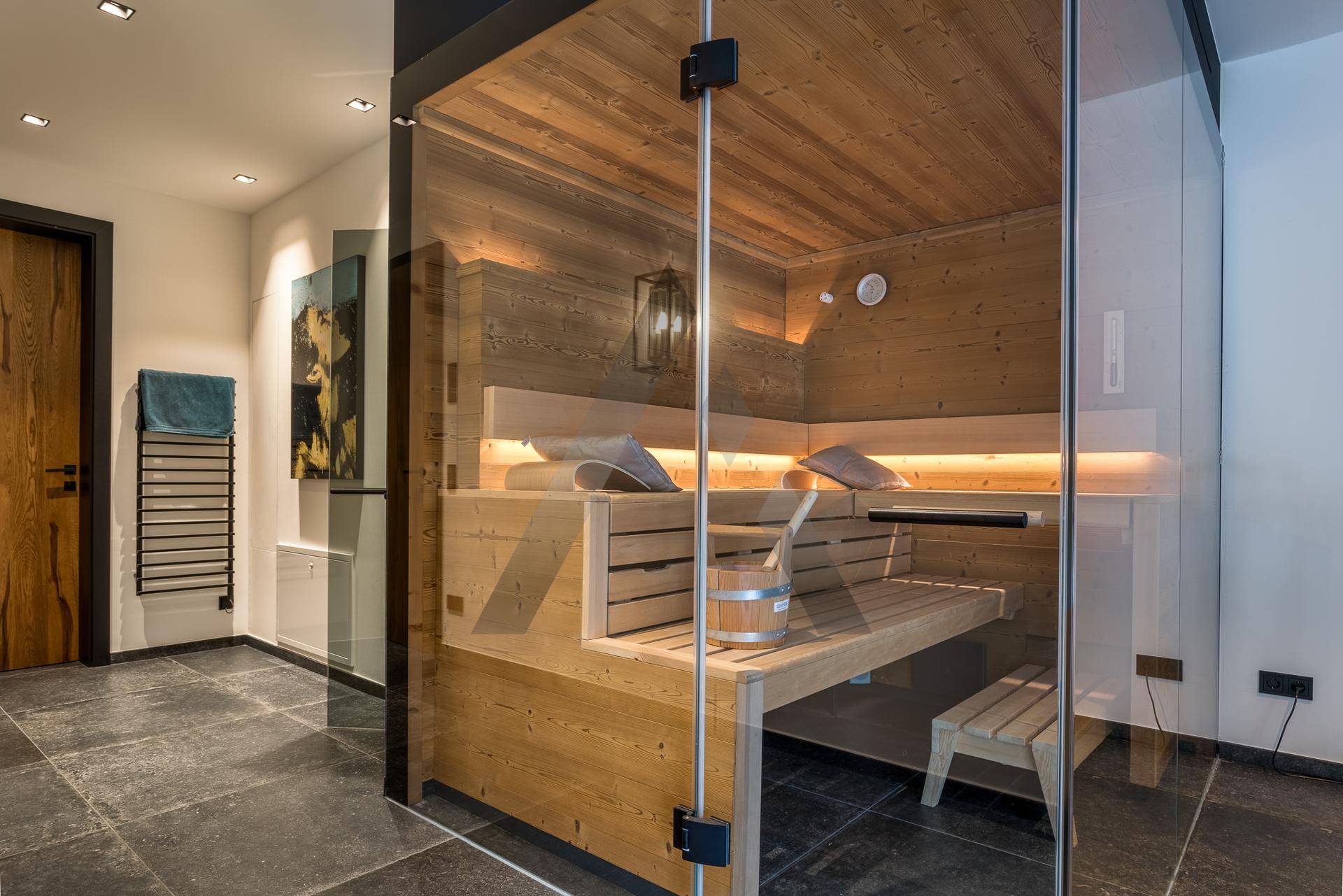 Moderne Sauna mit Holzverkleidung und Glasfront für entspannende Momente.