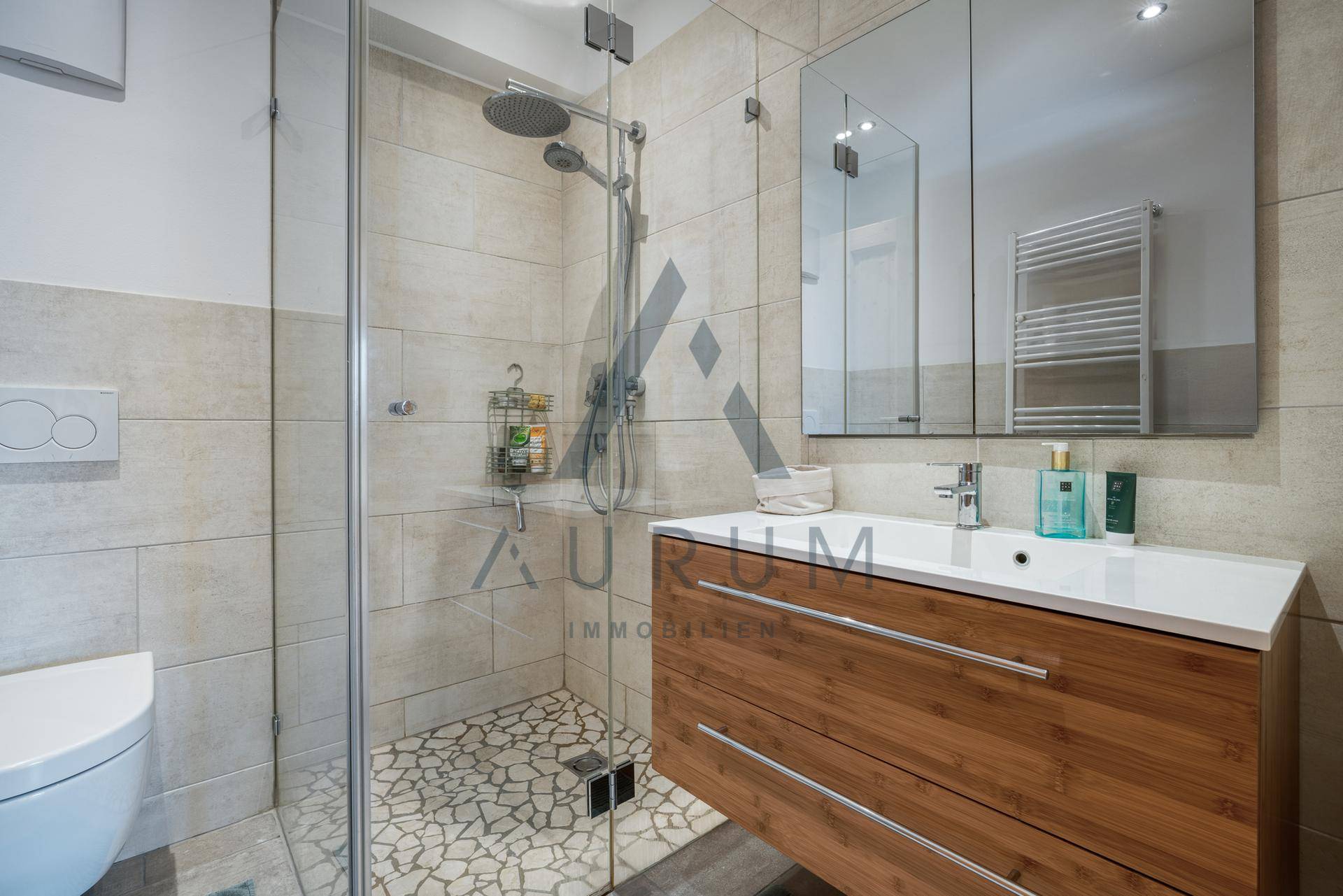 Modernes Badezimmer mit ebenerdiger Dusche, Einzelwaschbecken und beheiztem Handtuchhalter.