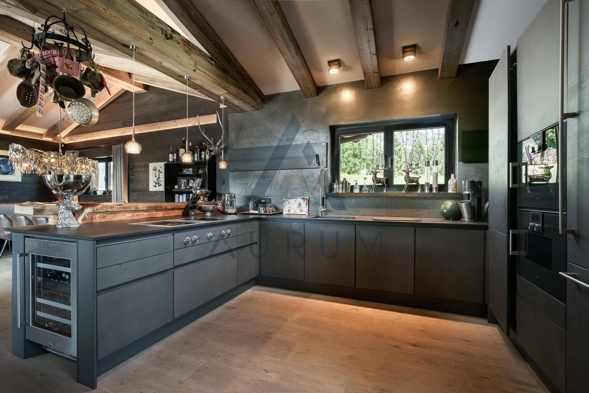 Moderne Küche mit dunklen Schränken, Holzbalkendecke und integriertem Weinkühler.