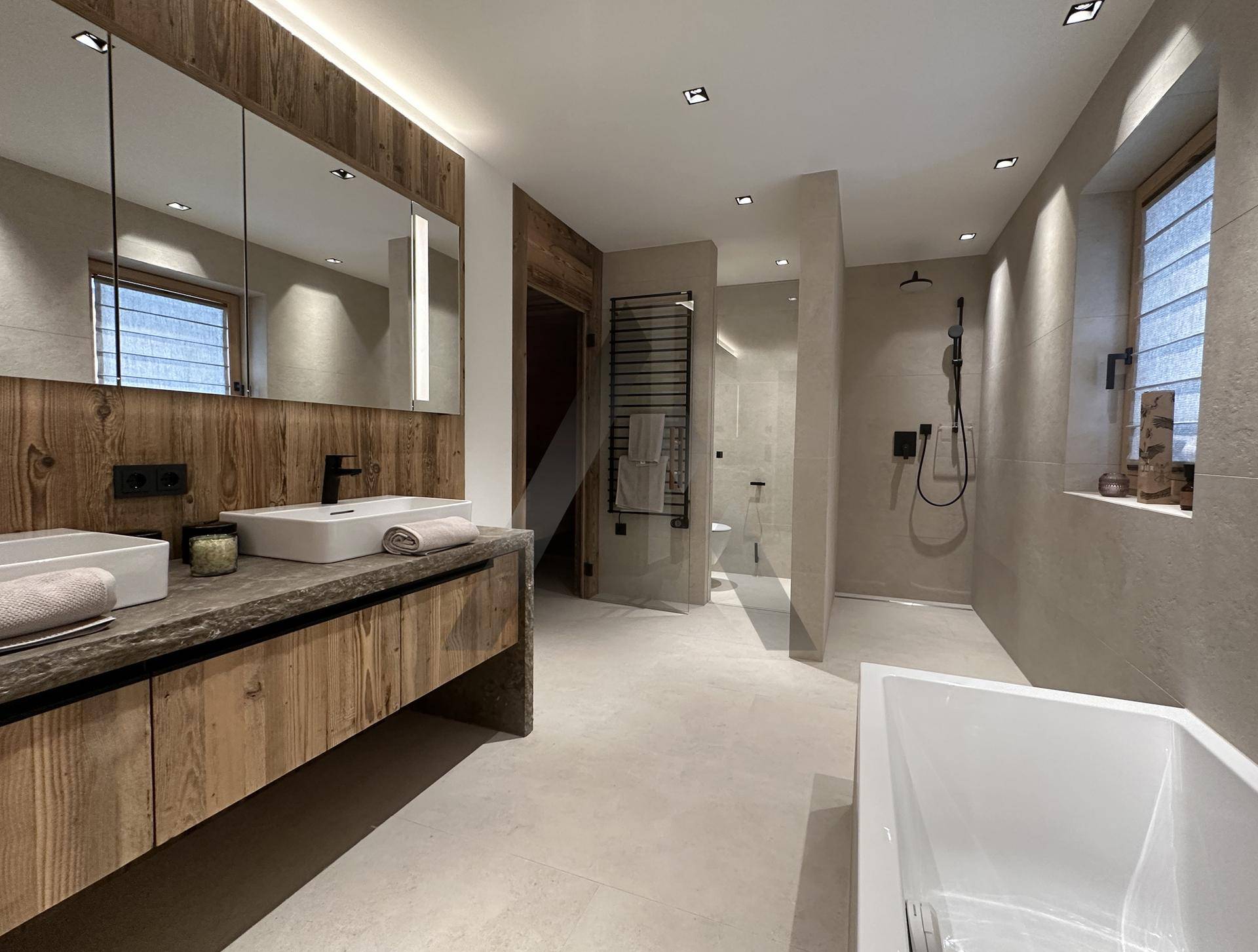 Modernes Badezimmer mit Doppelwaschbecken, begehbarer Dusche und Badewanne.