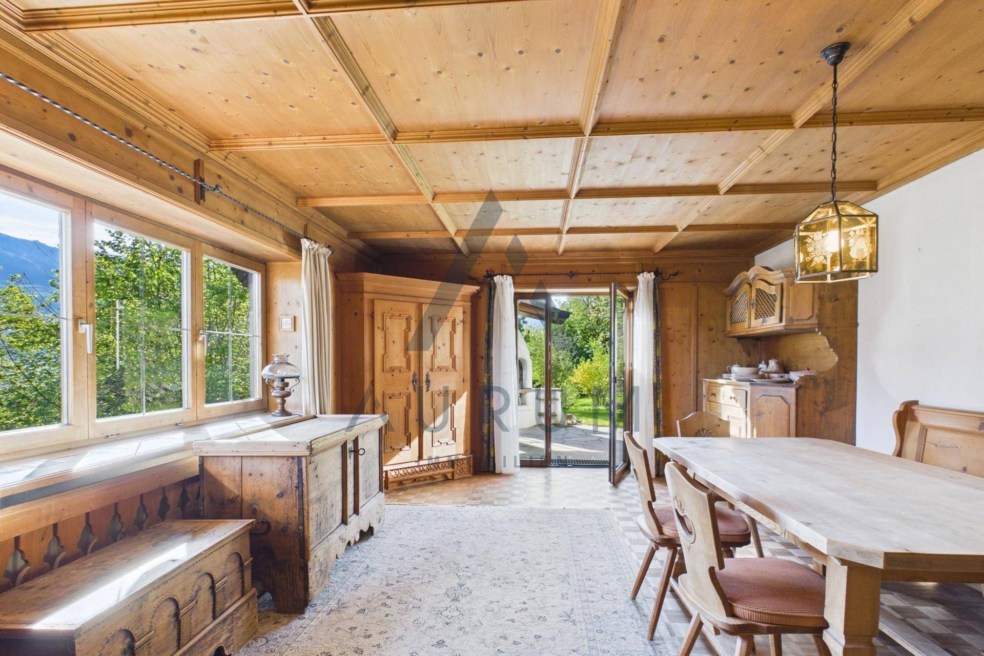 Traditioneller Essbereich mit Holztäfelung, Holzboden und Zugang zum Garten.