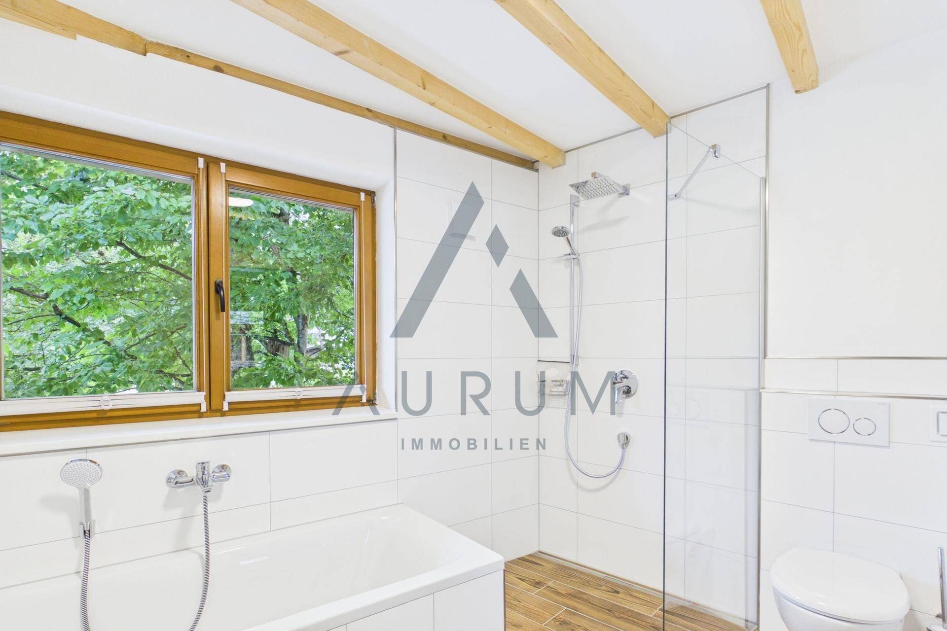 Modernes Badezimmer mit Badewanne, Dusche und Fenster für natürliche Belüftung.