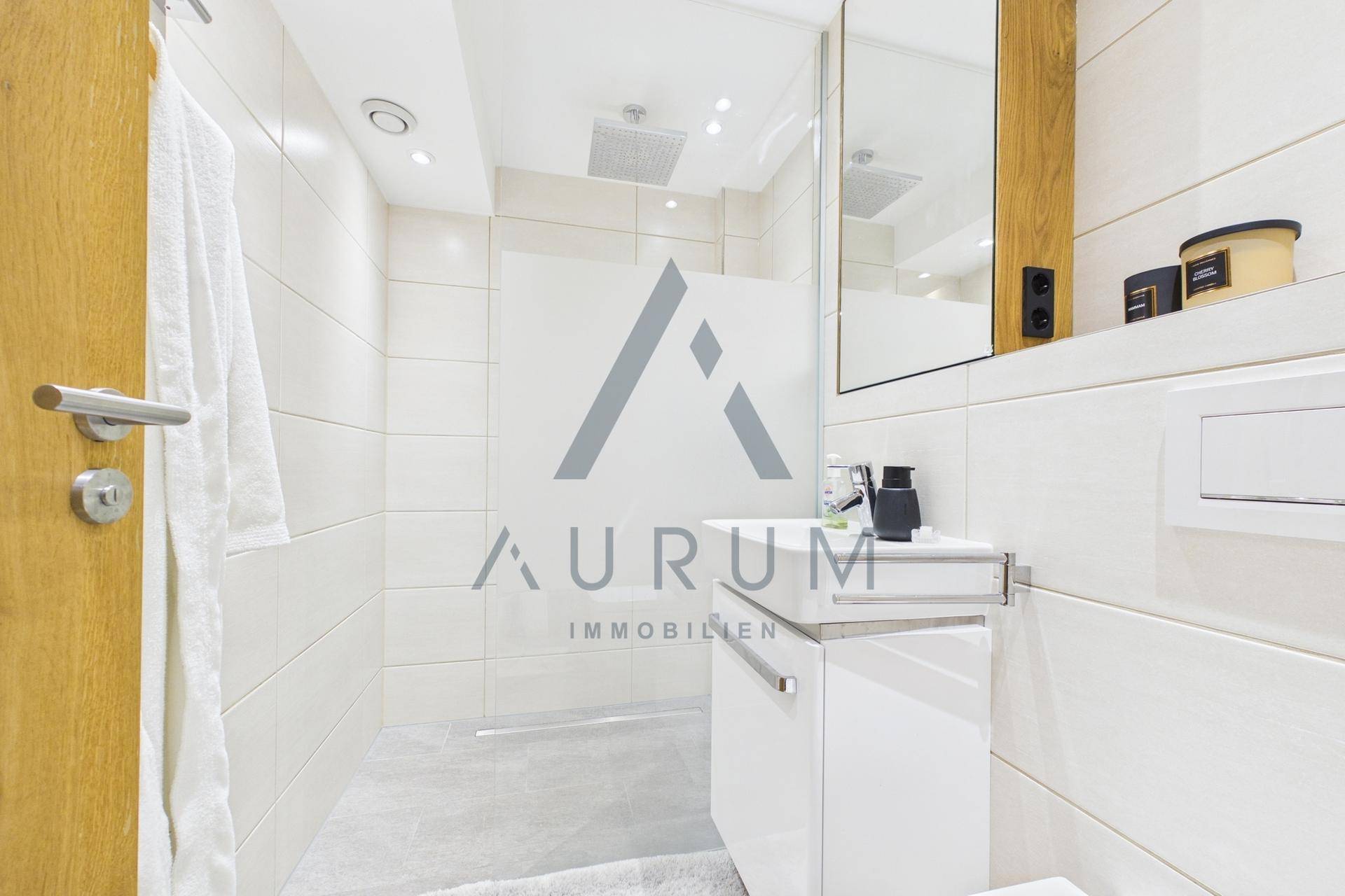 Modernes Badezimmer mit weißen Fliesen, ebenerdiger Dusche und minimalistischem Design.