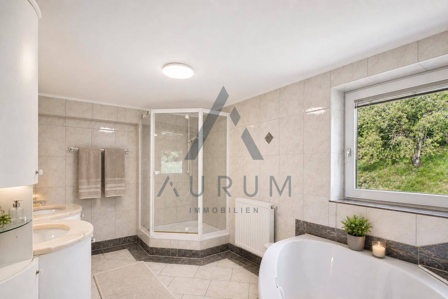 Helles Badezimmer mit Badewanne, Duschkabine, Doppelwaschbecken und Fenster.