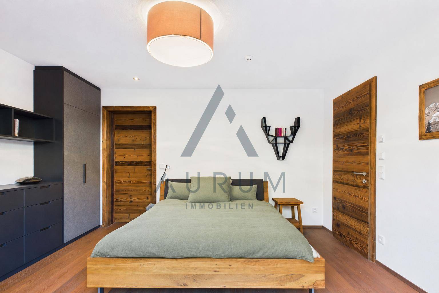 Gemütliches Schlafzimmer mit Holzboden, Holztüren und moderner Einrichtung.