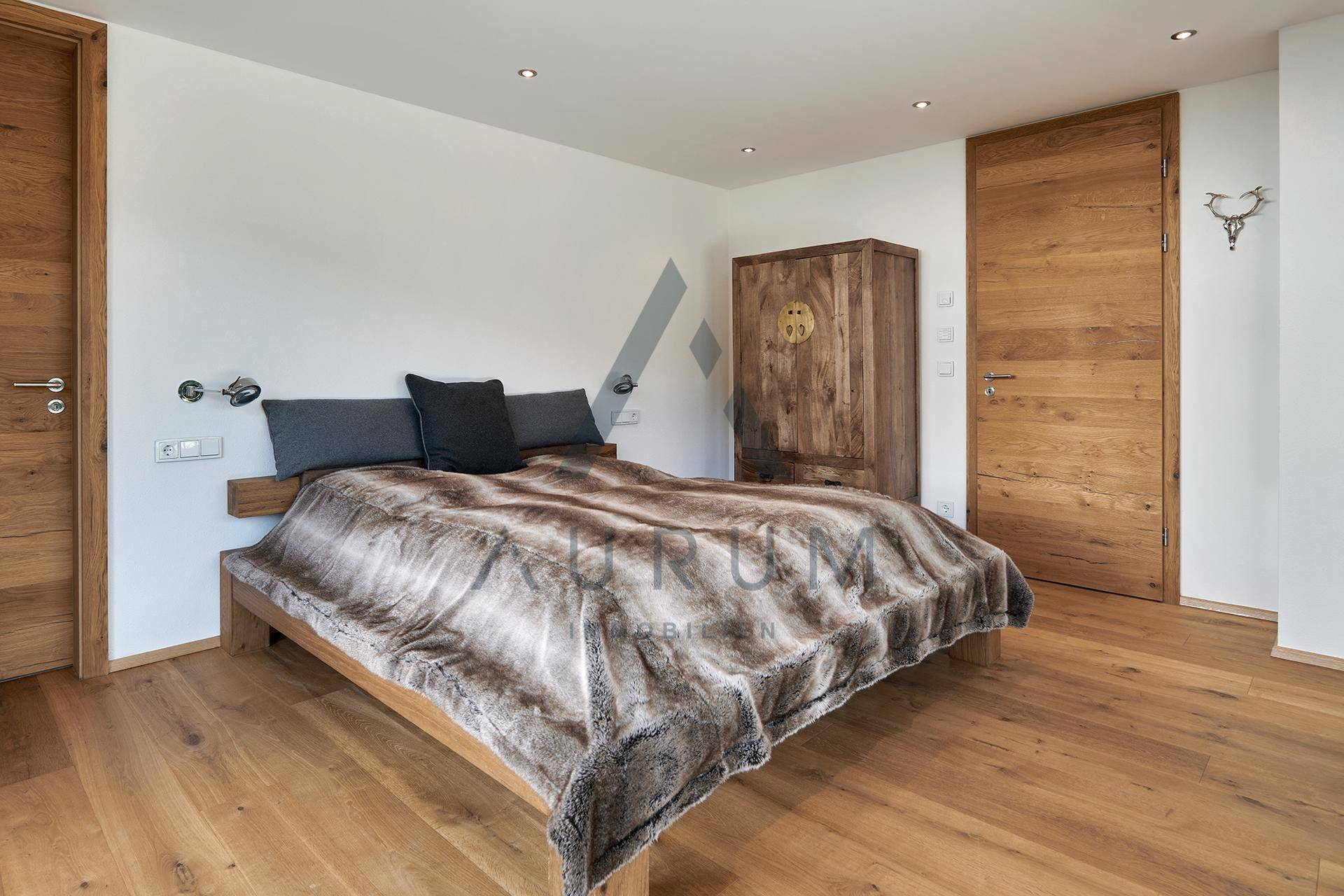 Gemütliches Schlafzimmer mit Holzboden, Holztüren und modernem Kleiderschrank.