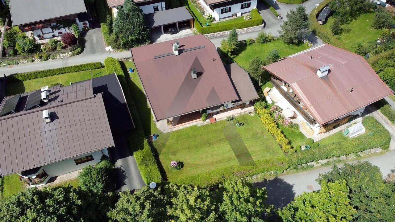 Weitläufige Luftaufnahme der Wohngegend mit gepflegten Gärten, Hecken und traditionellen Häusern.