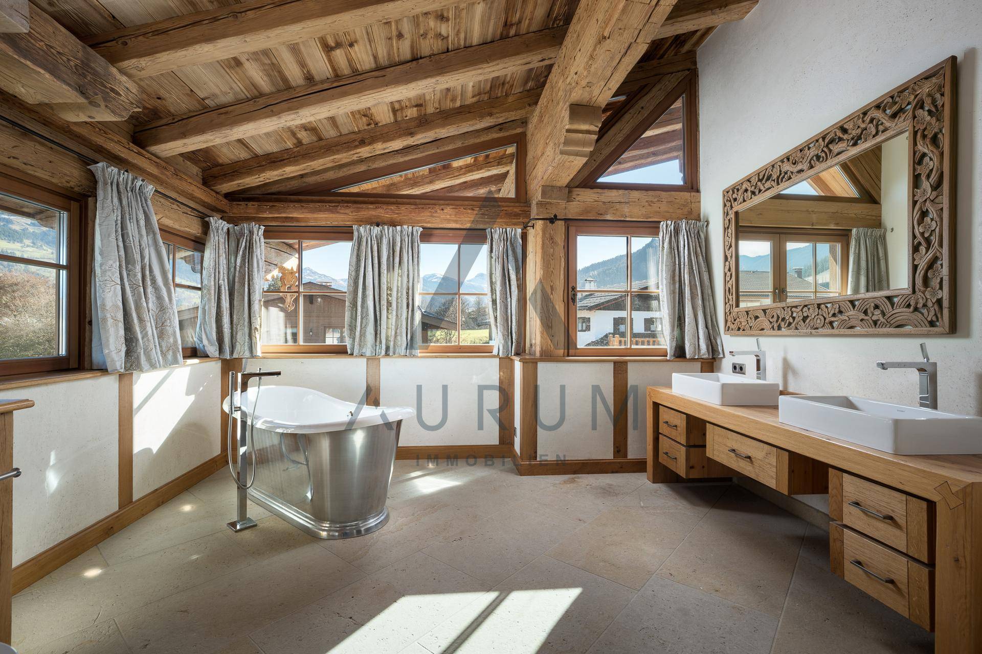 Luxuriöses Badezimmer mit freistehender Badewanne, Doppelwaschbecken und Bergblick.