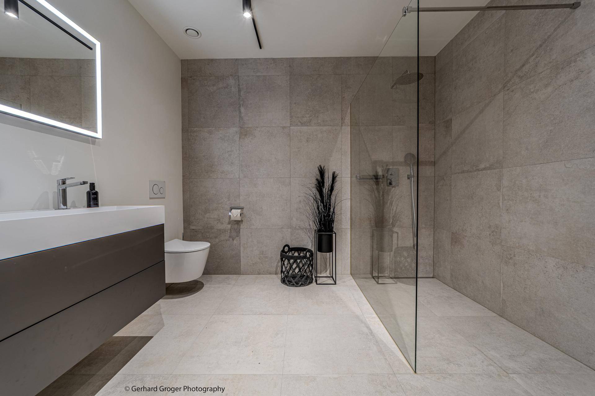 Modernes Badezimmer mit begehbarer Dusche, Wand-WC und Doppelwaschbecken.
