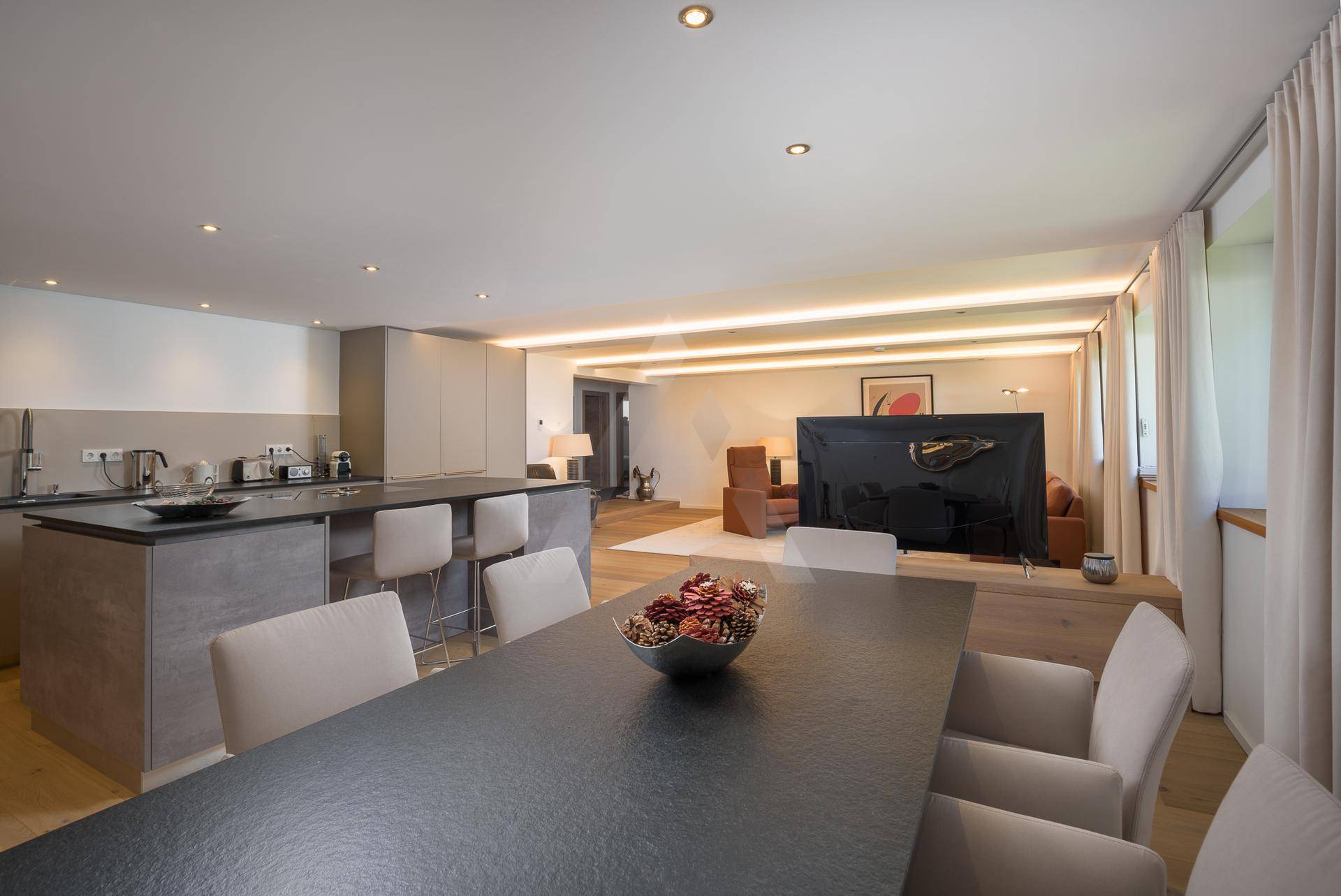 Eleganter Essbereich mit großem Tisch und Stühlen, offen zum Wohnzimmer und zur modernen Küche.